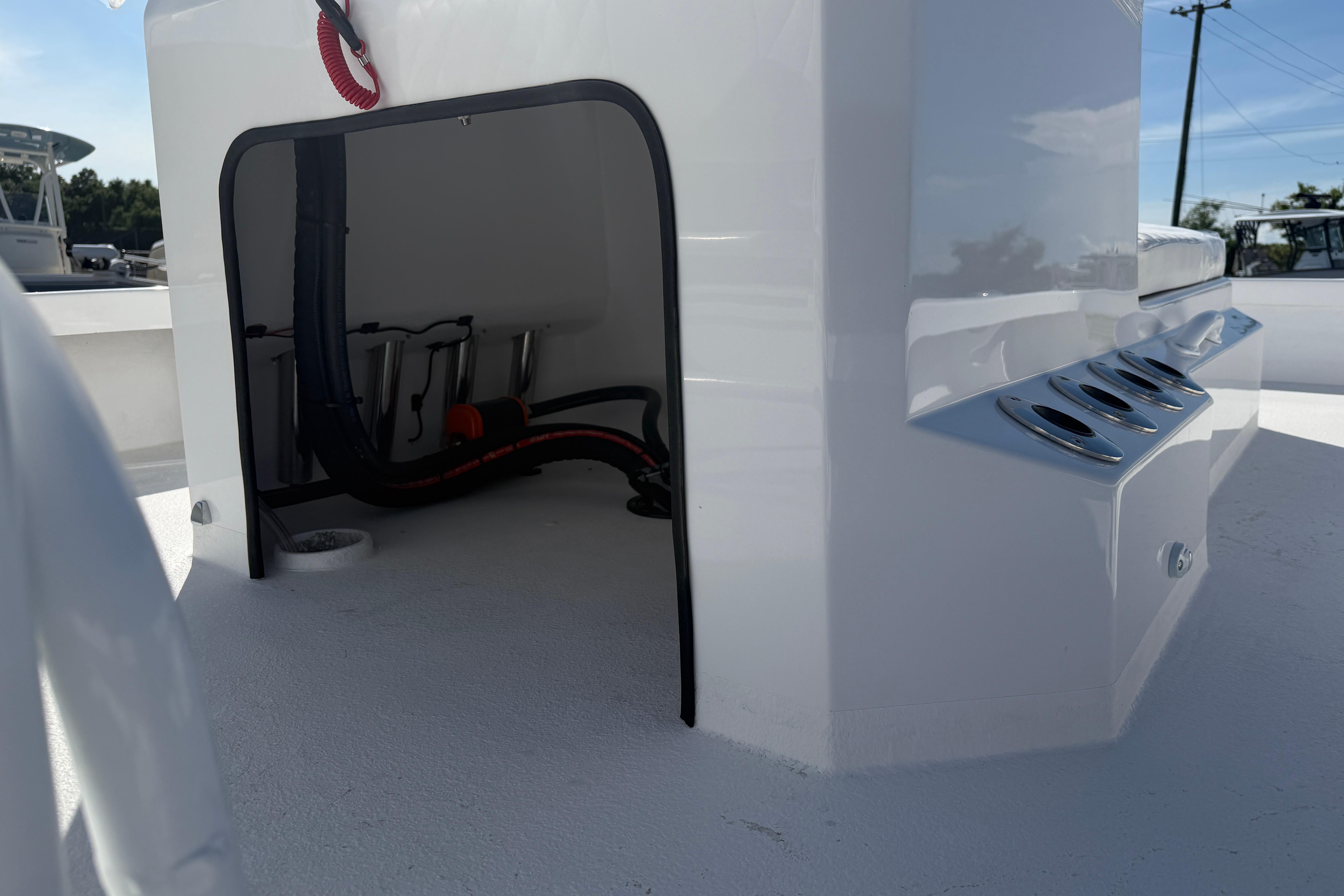 Storage compartment on a 2026 Skuta 24 Cat boat, featuring sleek design and rod holders.