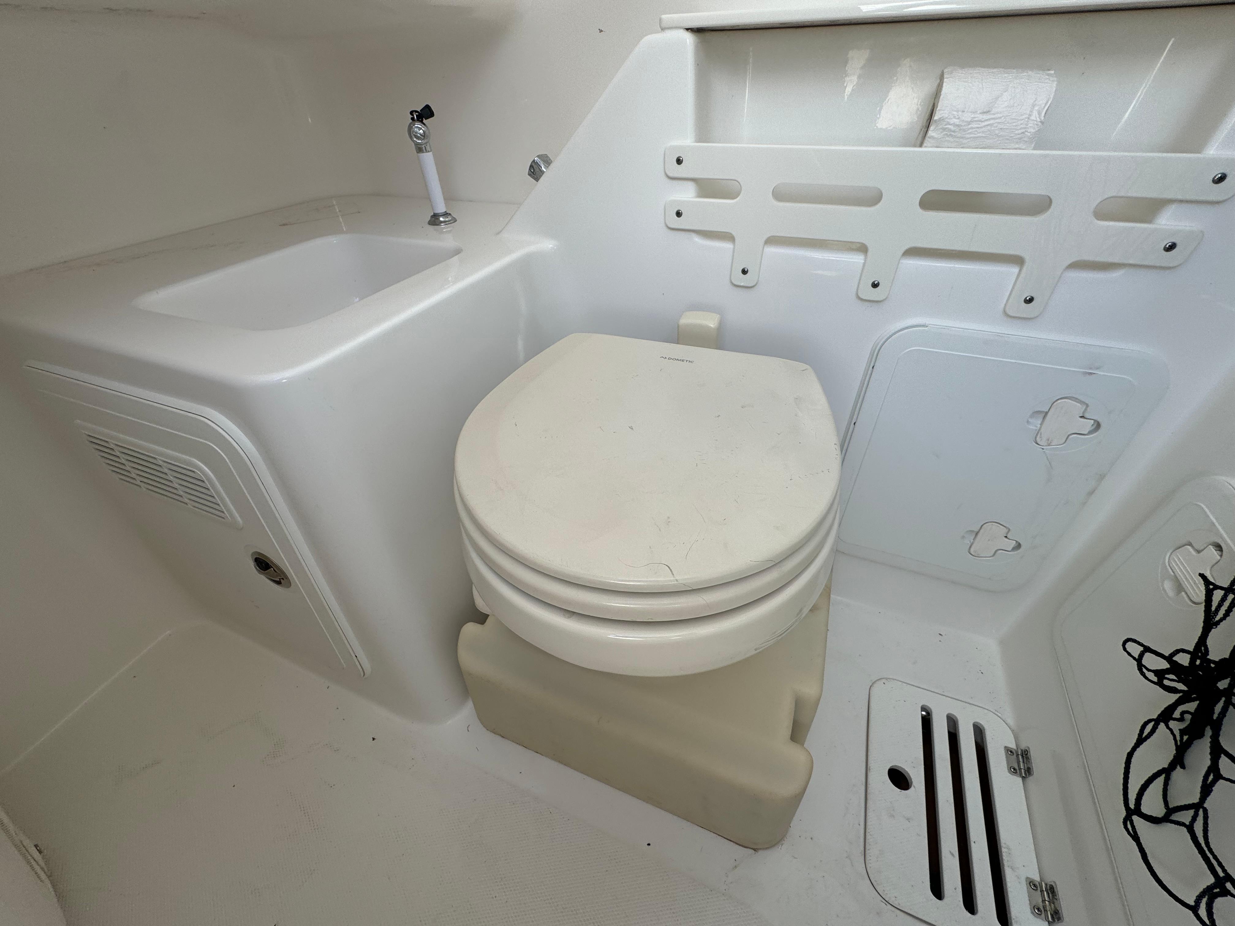 Interior of 2011 Everglades 325 Center Console boat with sink and toilet.