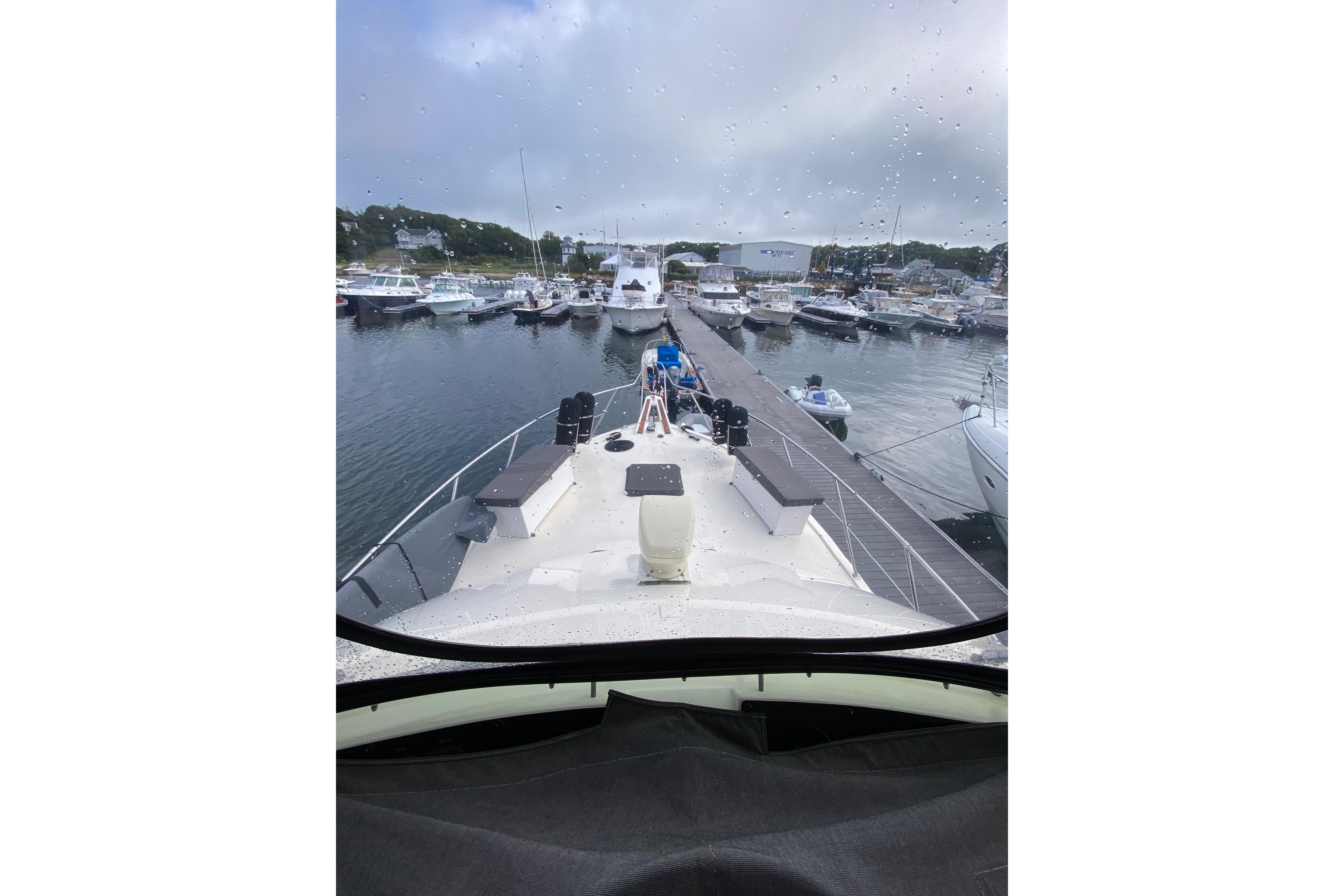 1991 Hatteras 40 Motor Yacht docked at a marina on a rainy day.