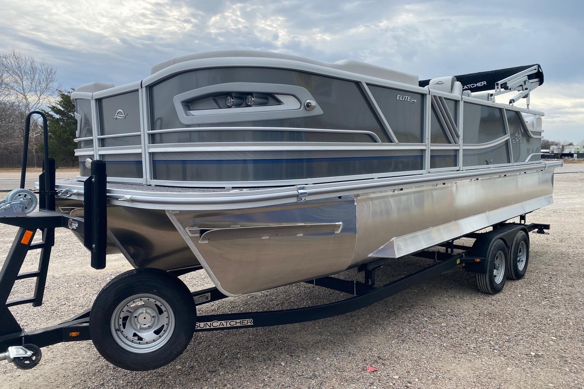2026 SunCatcher Diamond Elite 324 SS pontoon boat on trailer, parked outdoors.