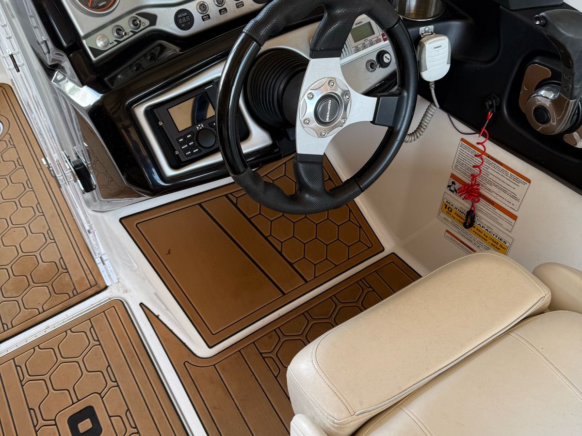 Interior of a 2012 Custom Challenger 210 boat with steering wheel and dashboard.