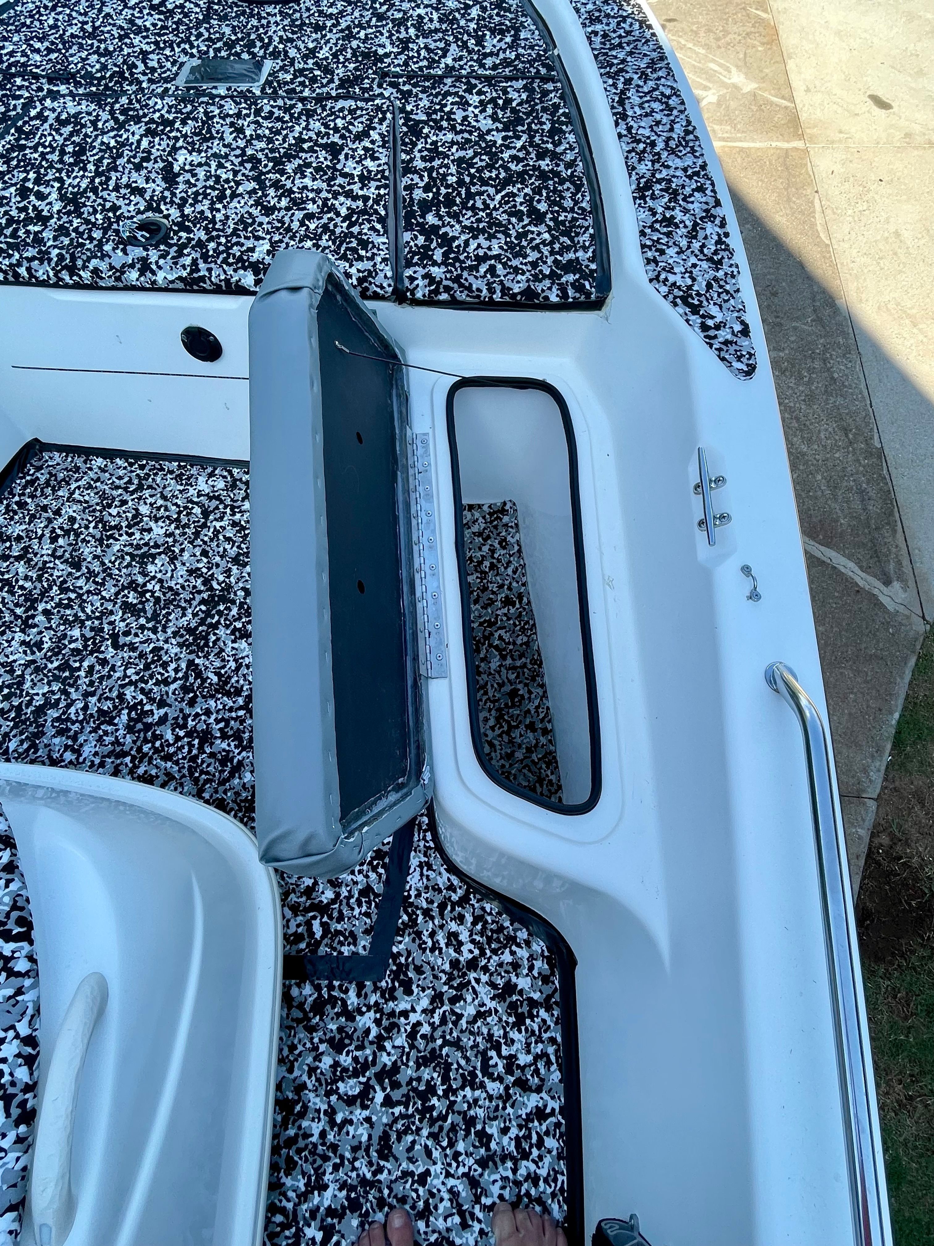 The image shows the deck of a 2006 Mako 2101 Inshore boat with an open storage compartment.
