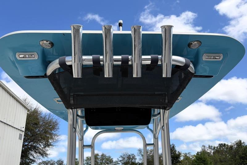 2025 Key West 210 Bay Reef boat with blue T-top and rod holders against a cloudy sky.