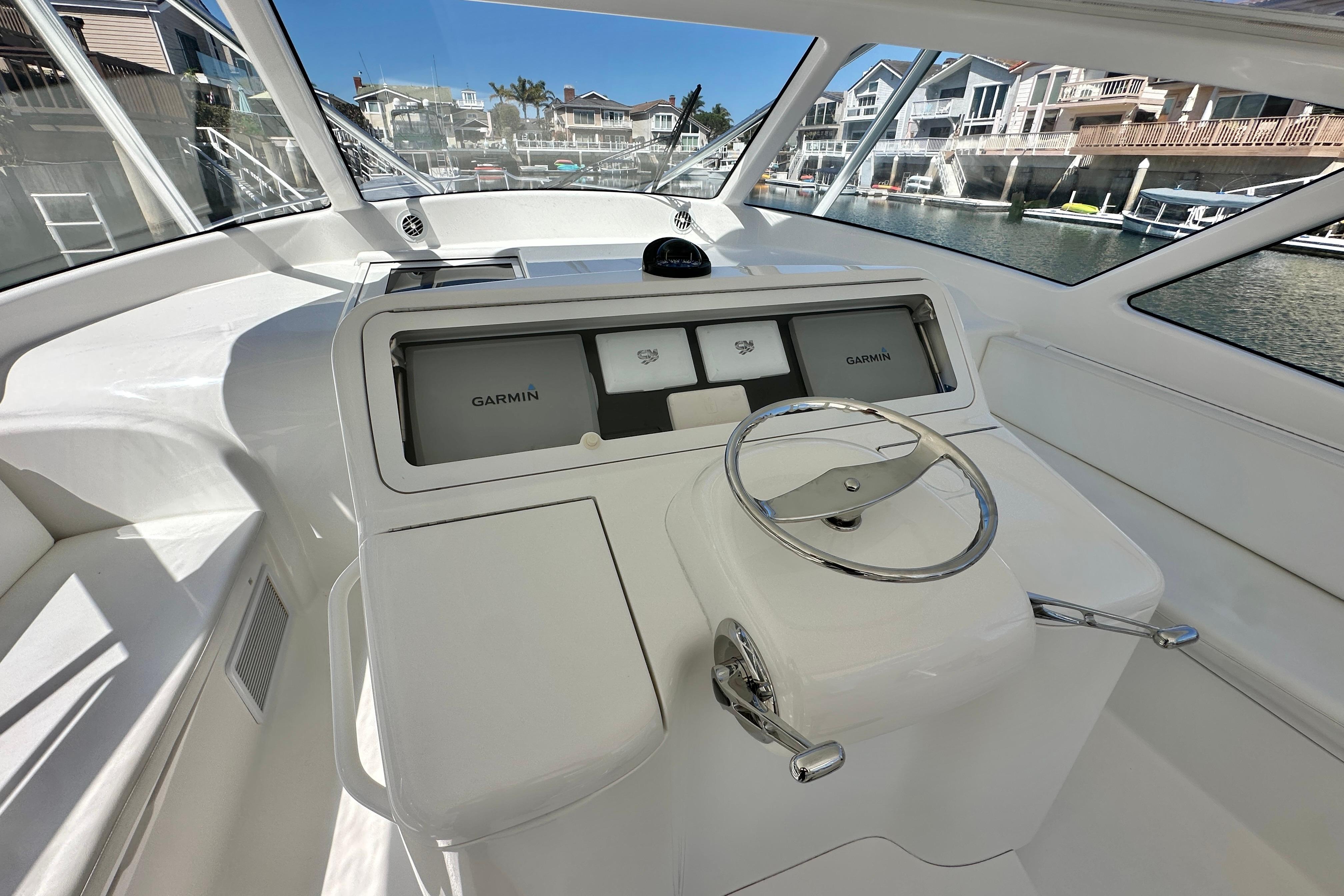 Helm of 2012 Viking 42 Open yacht with Garmin navigation system, docked in marina.