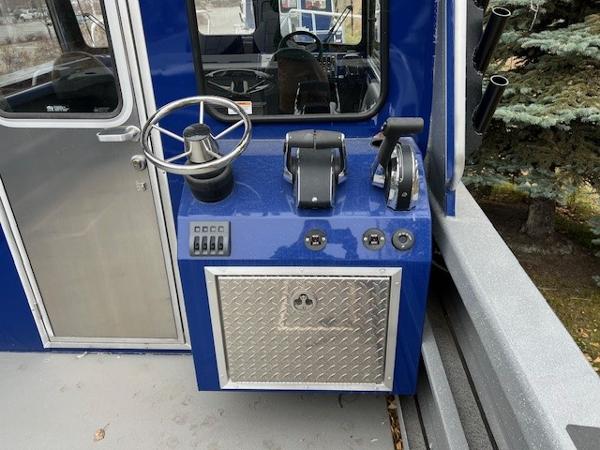 2024 Spartan 26 Maximus Pro XL boat control panel with steering wheel and throttle levers.