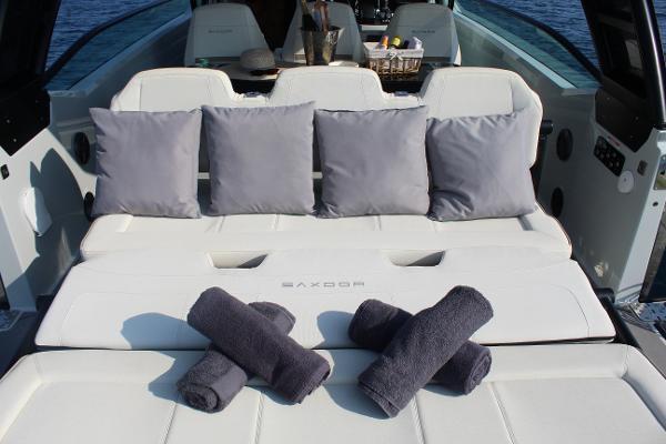2024 Saxdor 320 GTO boat interior with cushions and towels on white seating.