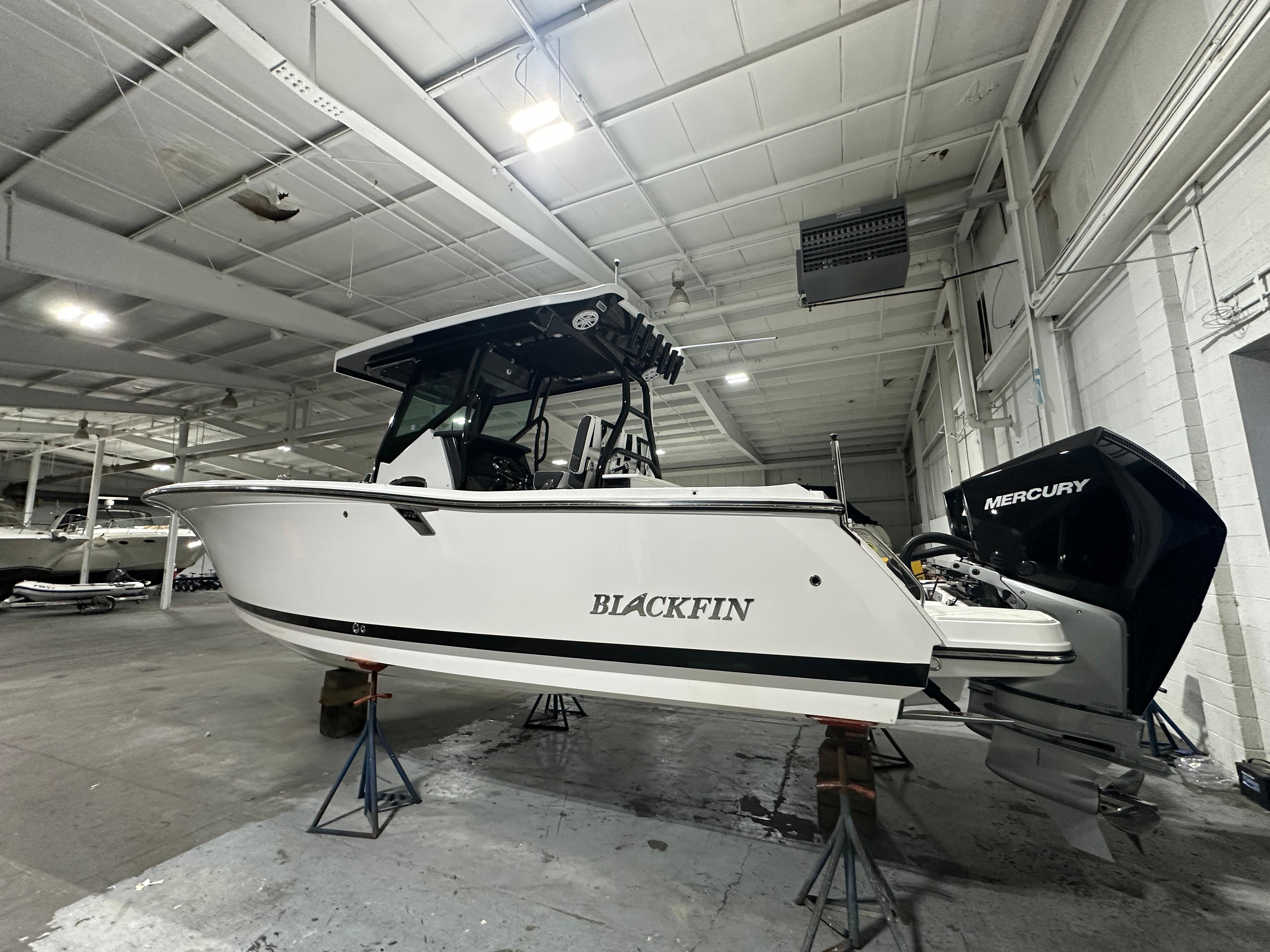 2025 Blackfin 272CC boat in indoor storage, featuring Mercury outboard engine.