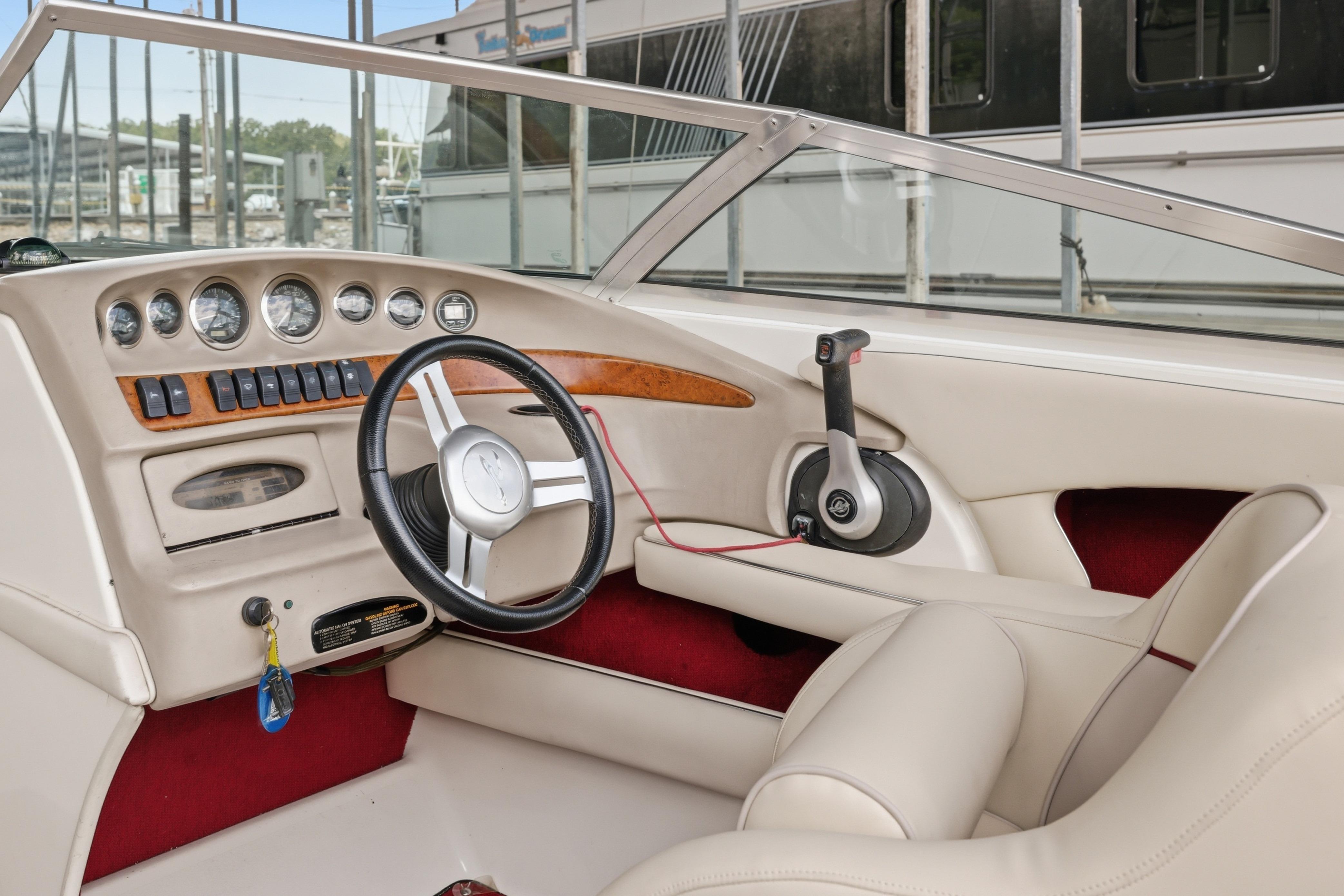 1997 Sea Ray 230 Signature boat interior with steering wheel and dashboard controls.