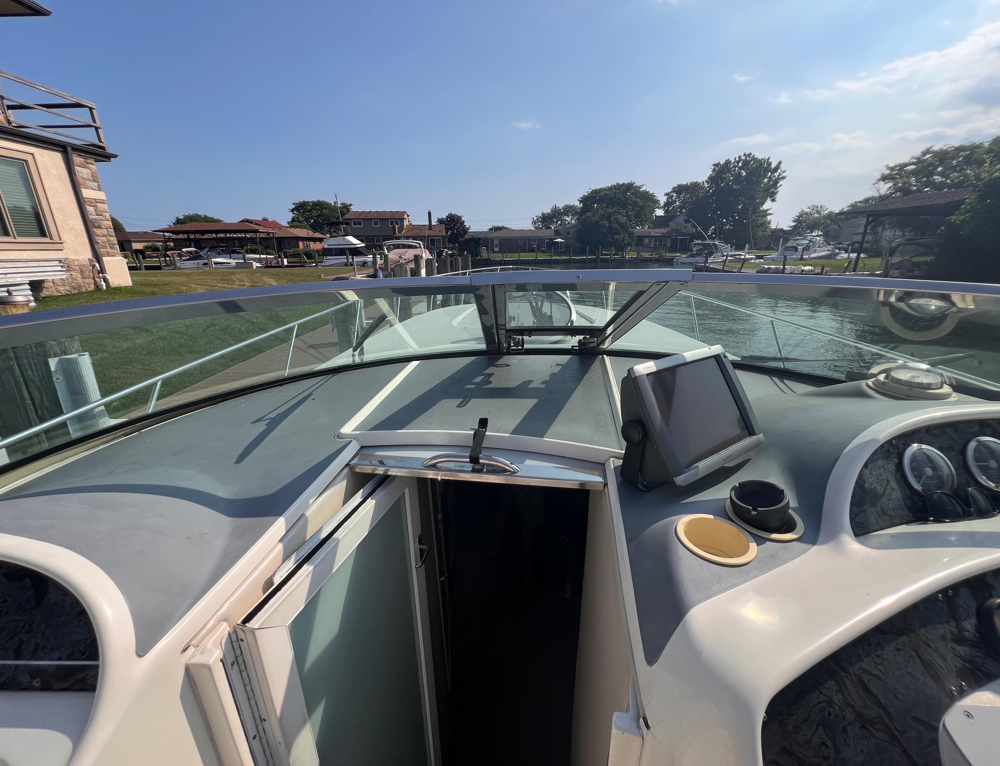 2000 Wellcraft 45 Excalibur boat cockpit with dashboard and open cabin door.