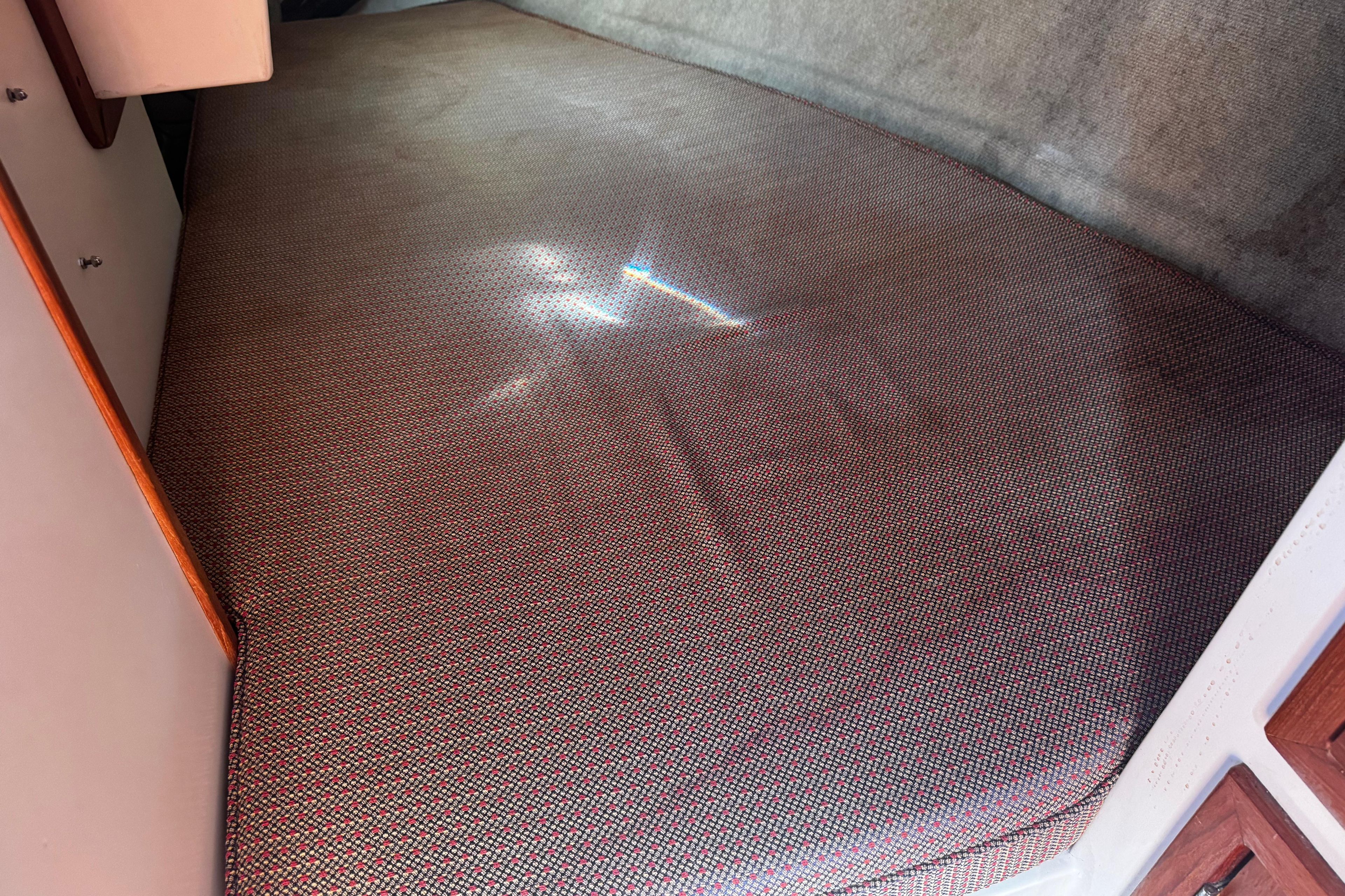 Interior cabin bed of 1984 Hunter 37 Cutter sailboat with patterned upholstery.