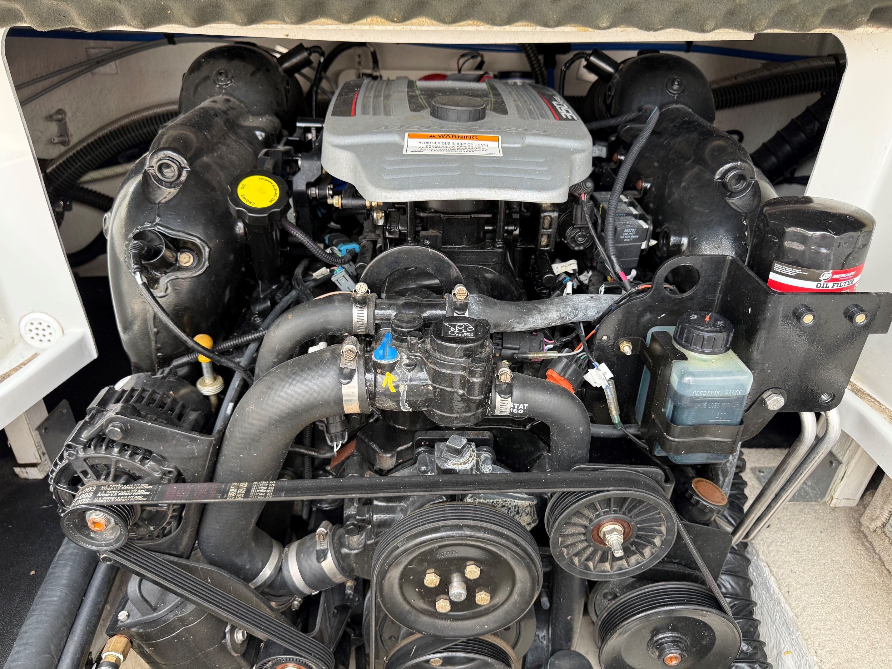 The engine compartment of a 2012 Crownline 252 EX shows a well-maintained engine with various components.