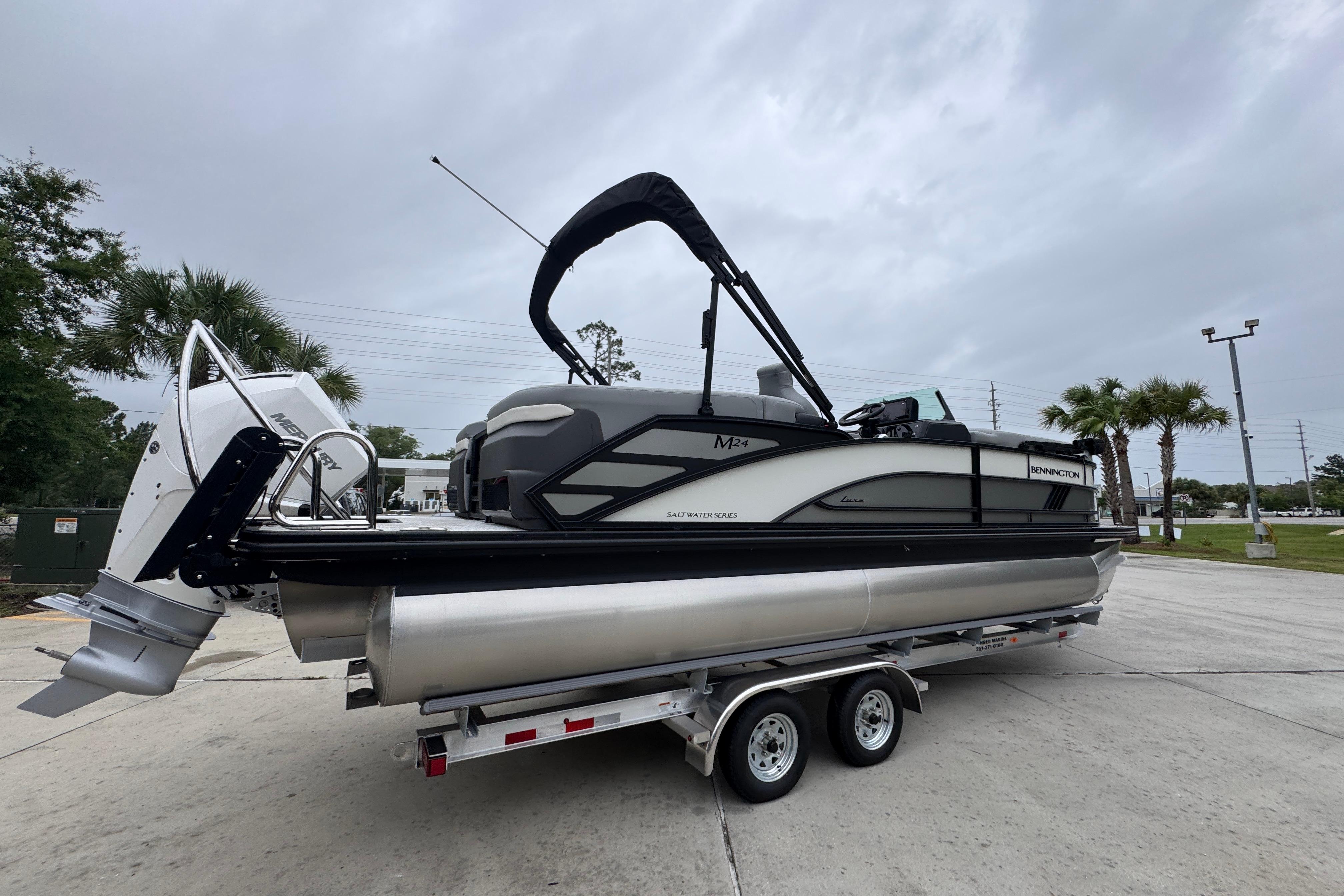 2027 Bennington 24 MFB pontoon boat on trailer, parked outdoors.