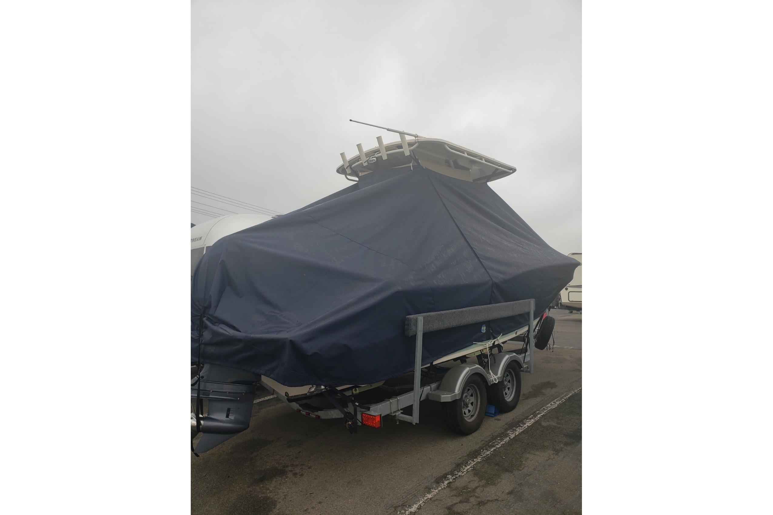 2018 Grady-White Fisherman 216 boat covered on trailer, overcast sky.