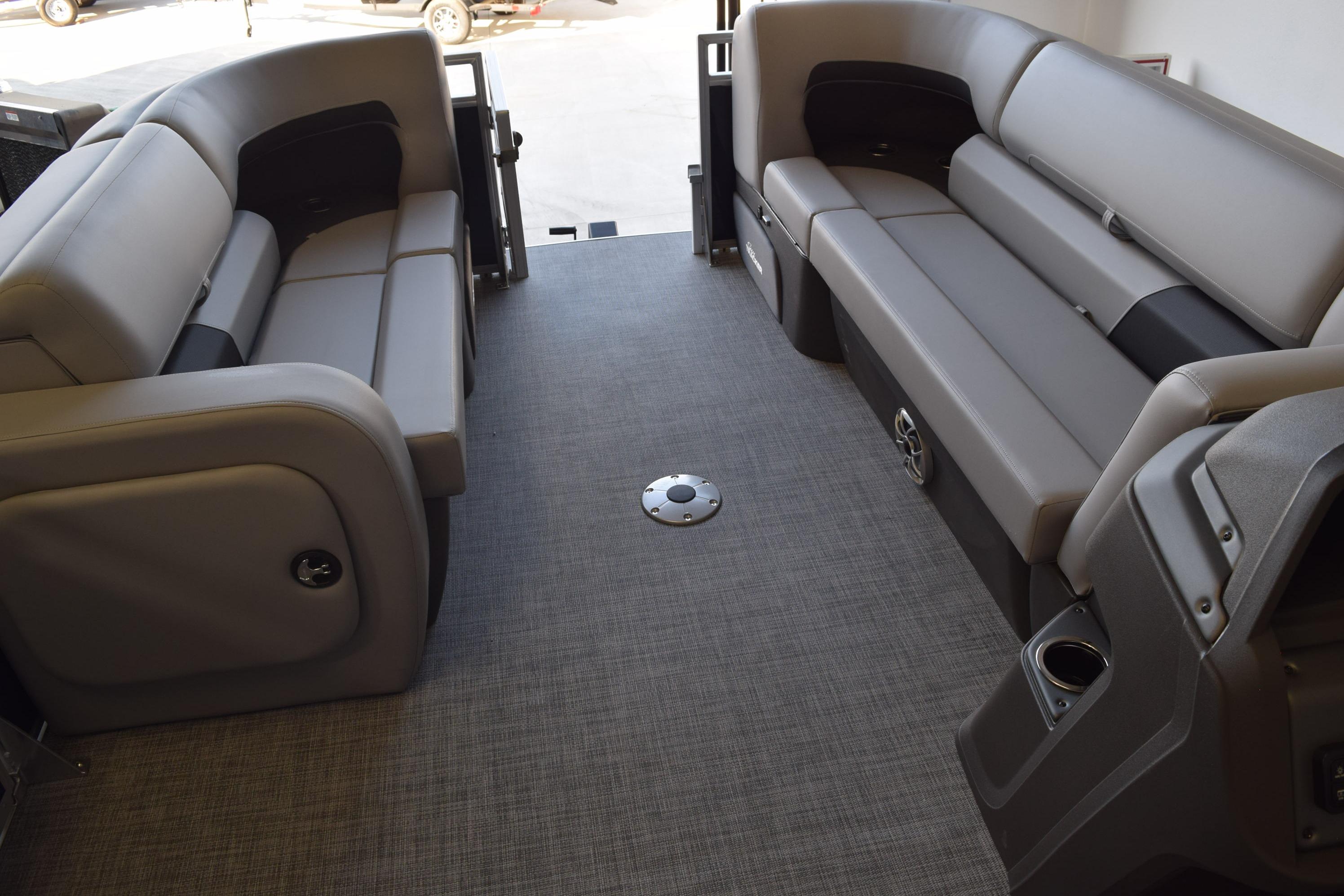 2026 Sun Tracker SportFish 22 DLX interior with gray seating and carpeted flooring.