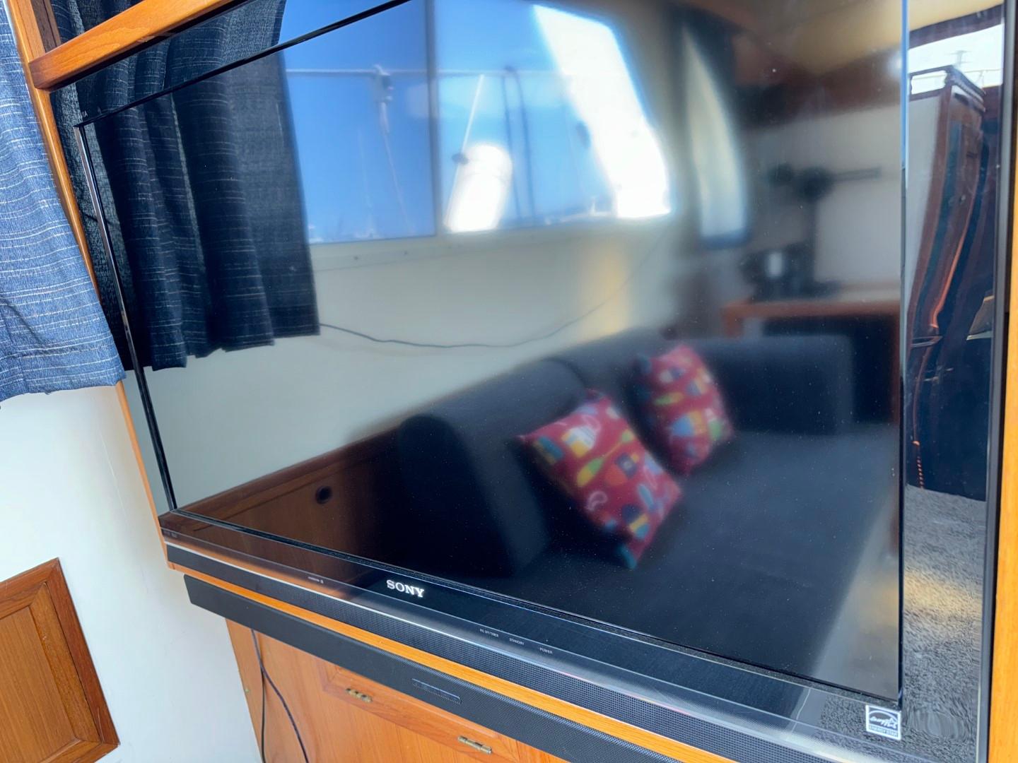 1987 Kadey-Krogen Silhouette interior with Sony TV and colorful cushions on a sofa.