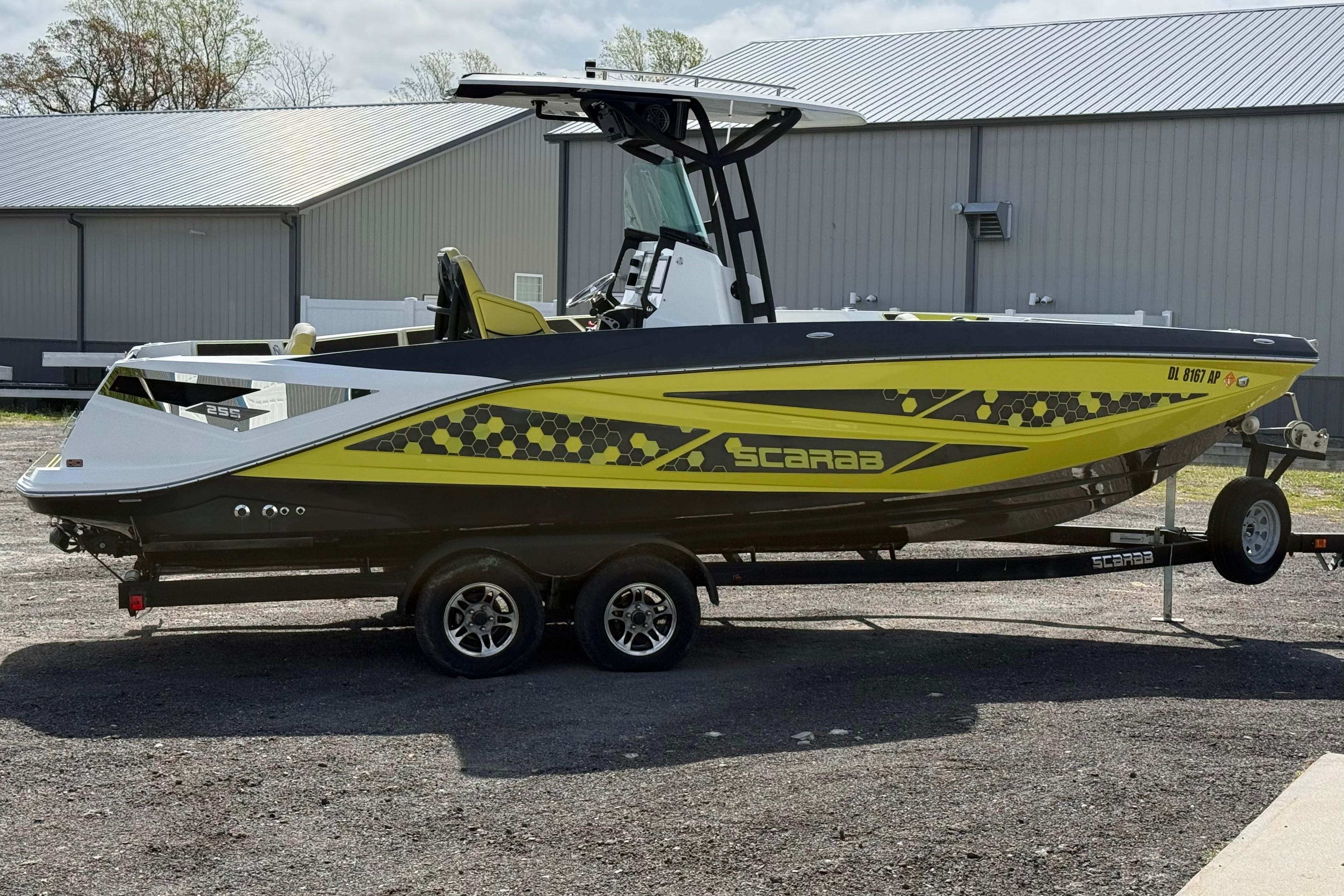 2022 Scarab 255 Open ID boat on trailer, featuring vibrant yellow and black design.