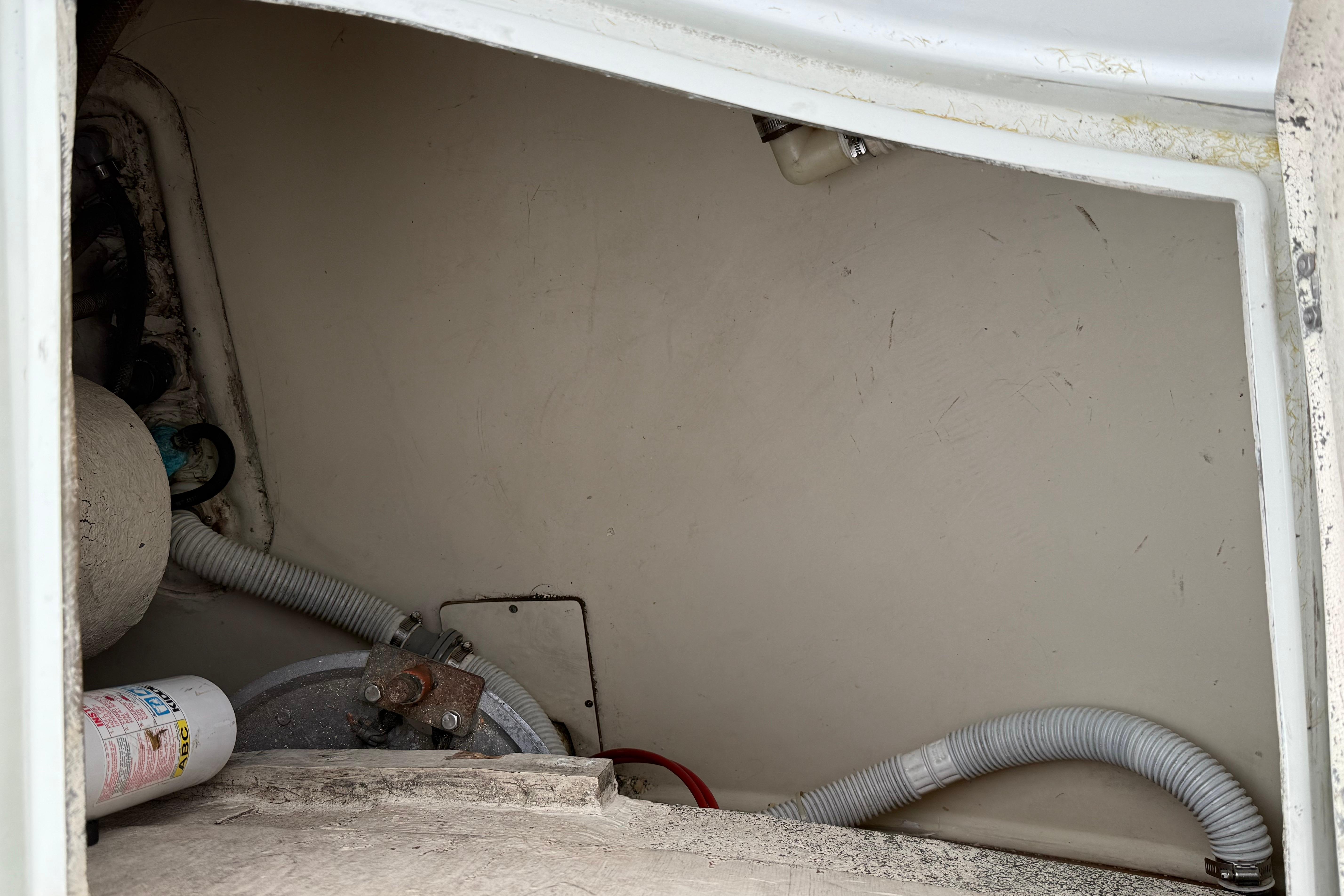 Interior view of 1988 Ericson 32-200 sailboat compartment with hoses and equipment.