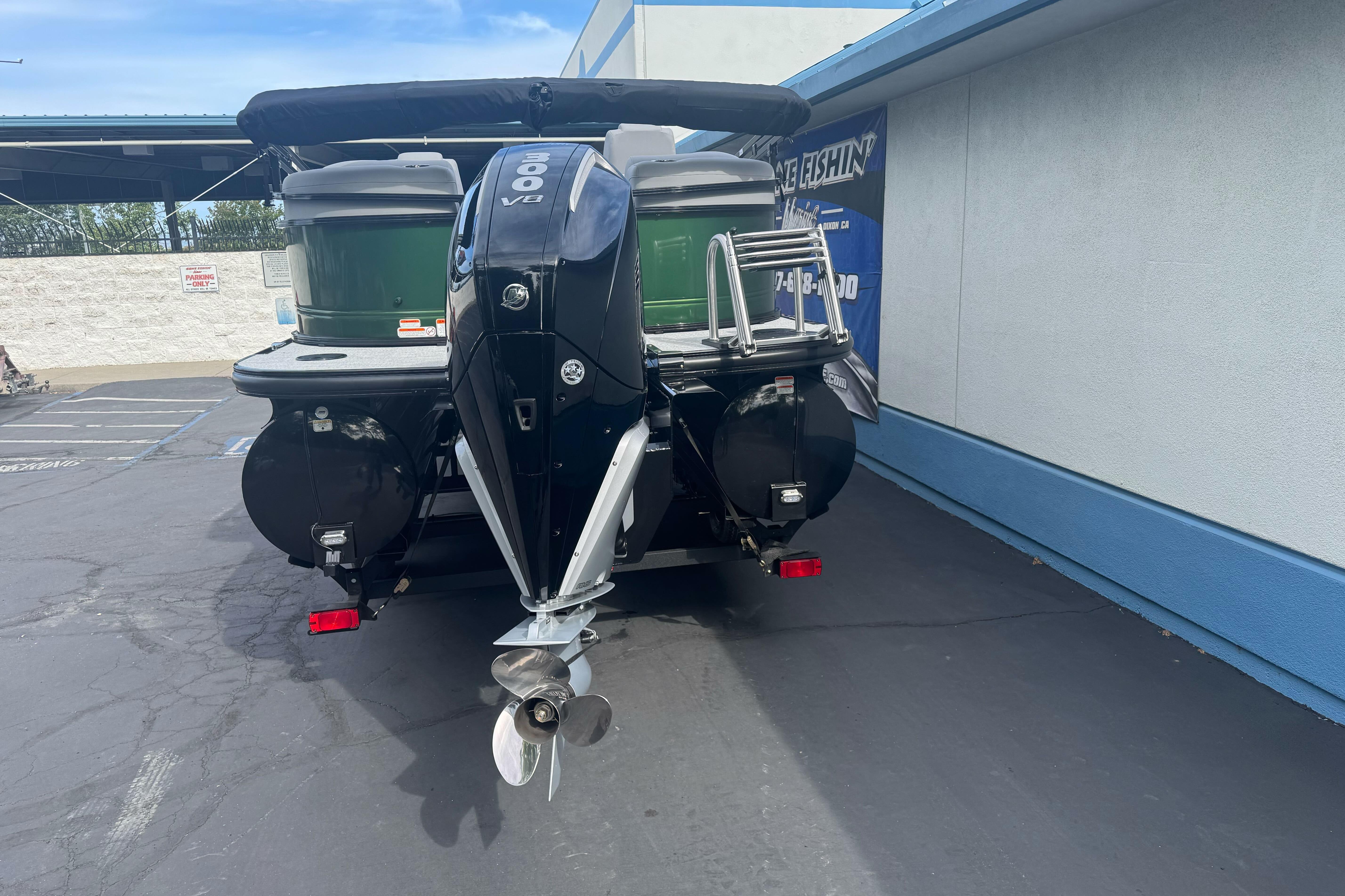 2026 Regency 250 DL boat with powerful outboard motor in a parking lot.