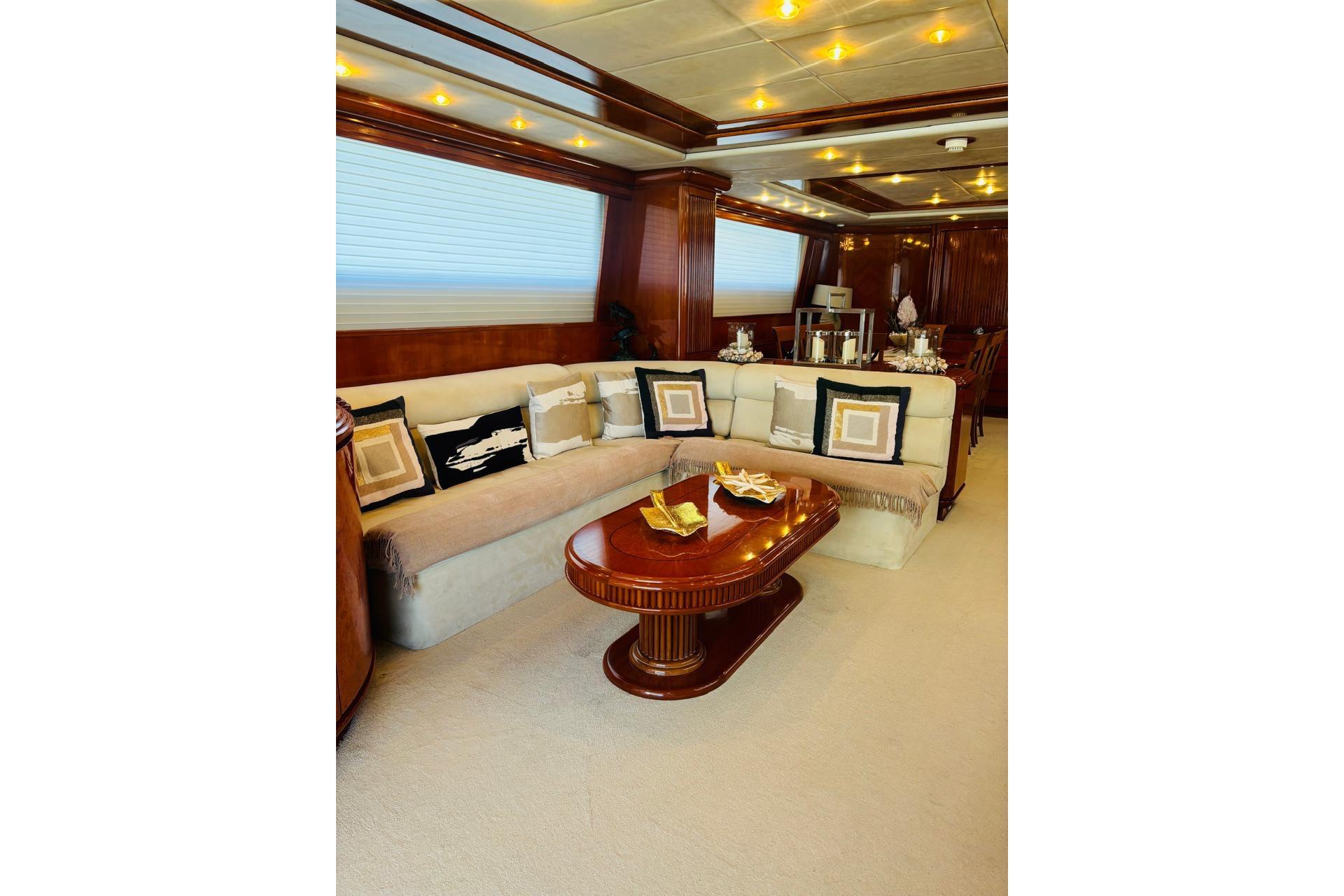 Luxurious interior of a 2000 Falcon 100 yacht with elegant seating and wooden accents.