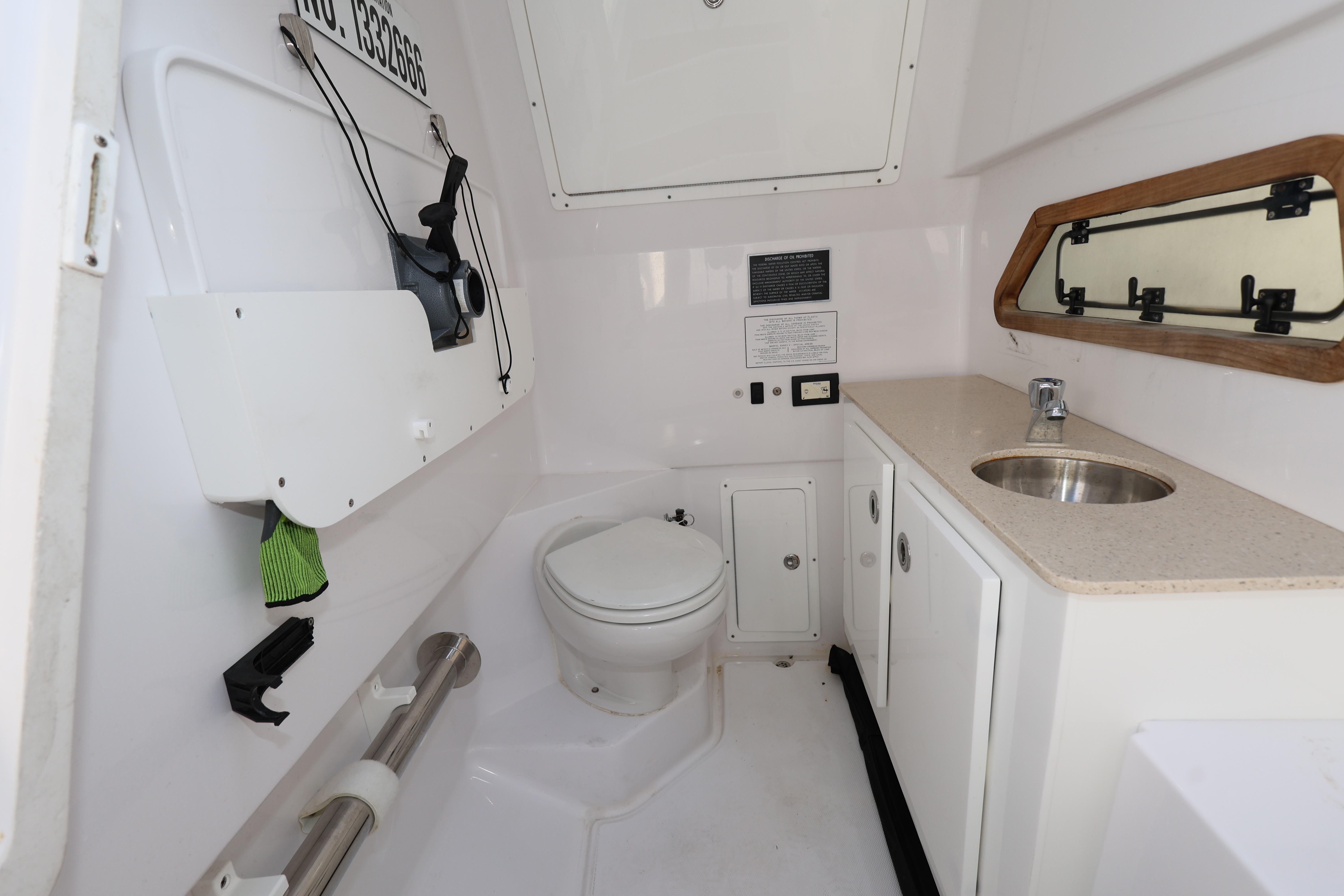 2023 Bertram 28 CC boat interior with toilet, sink, and storage cabinets.