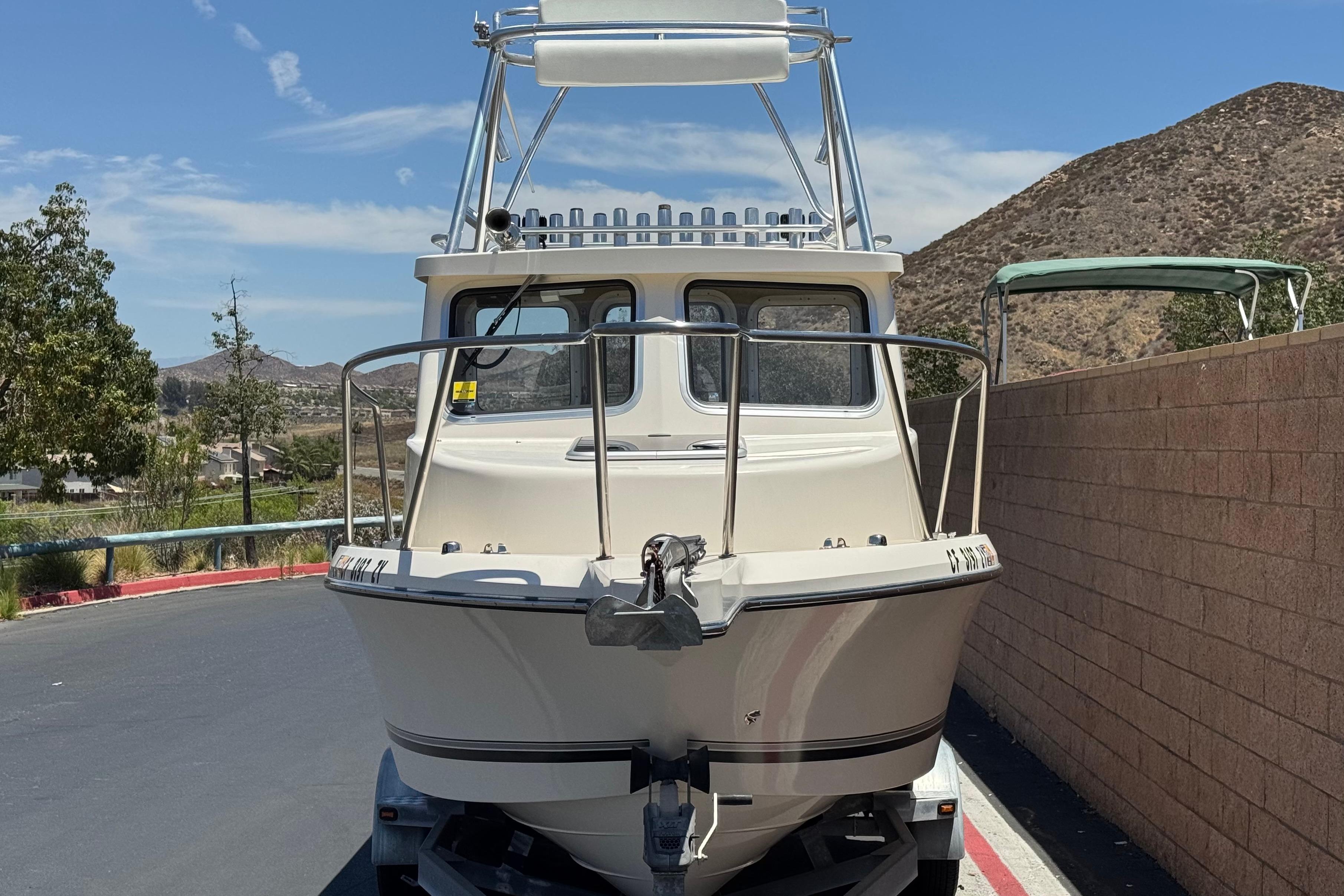 2017 Defiance Admiral 220 EX boat on trailer, parked near a brick wall.