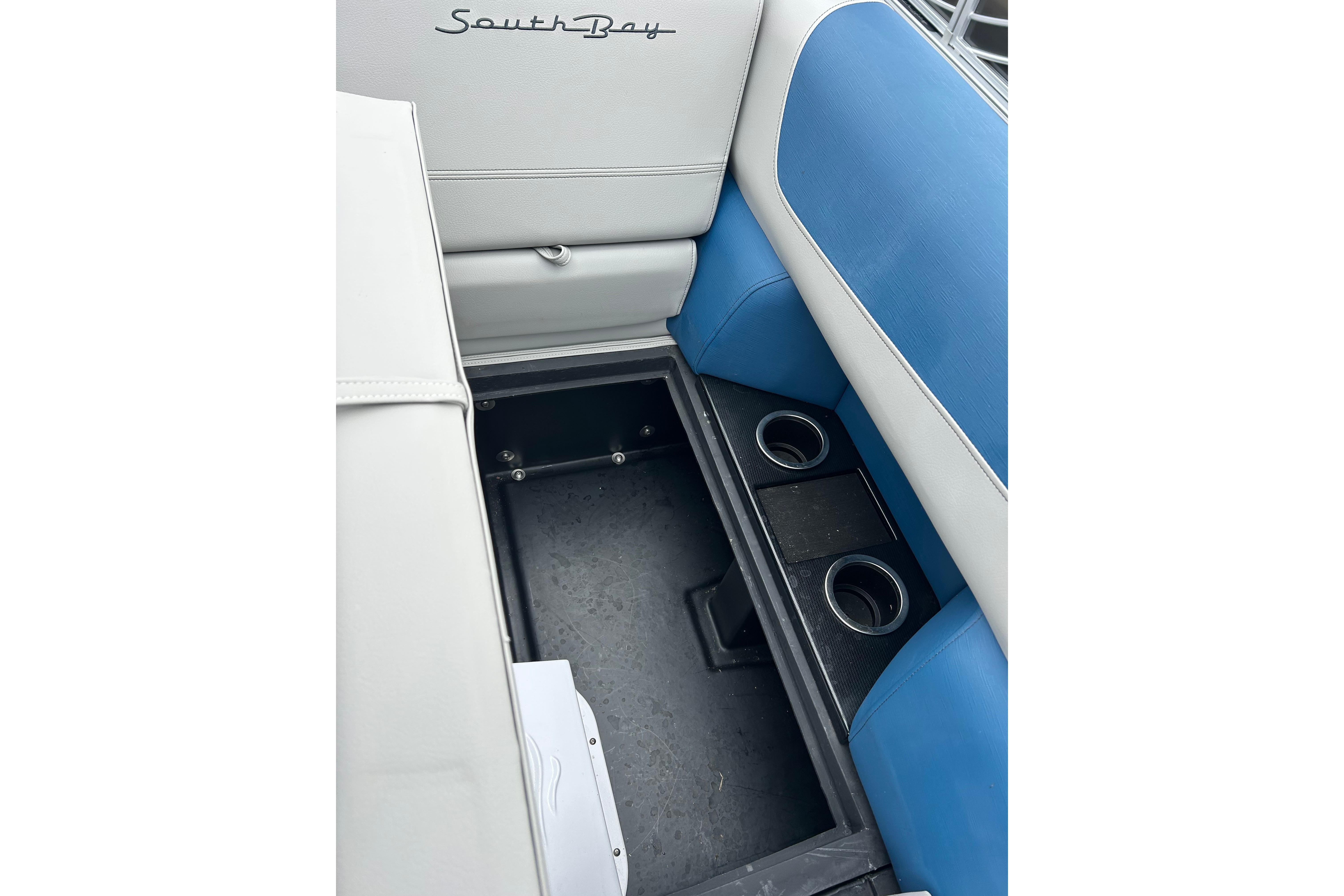 Interior of 2025 Southbay 224RSLE25 boat with storage compartment and cup holders.