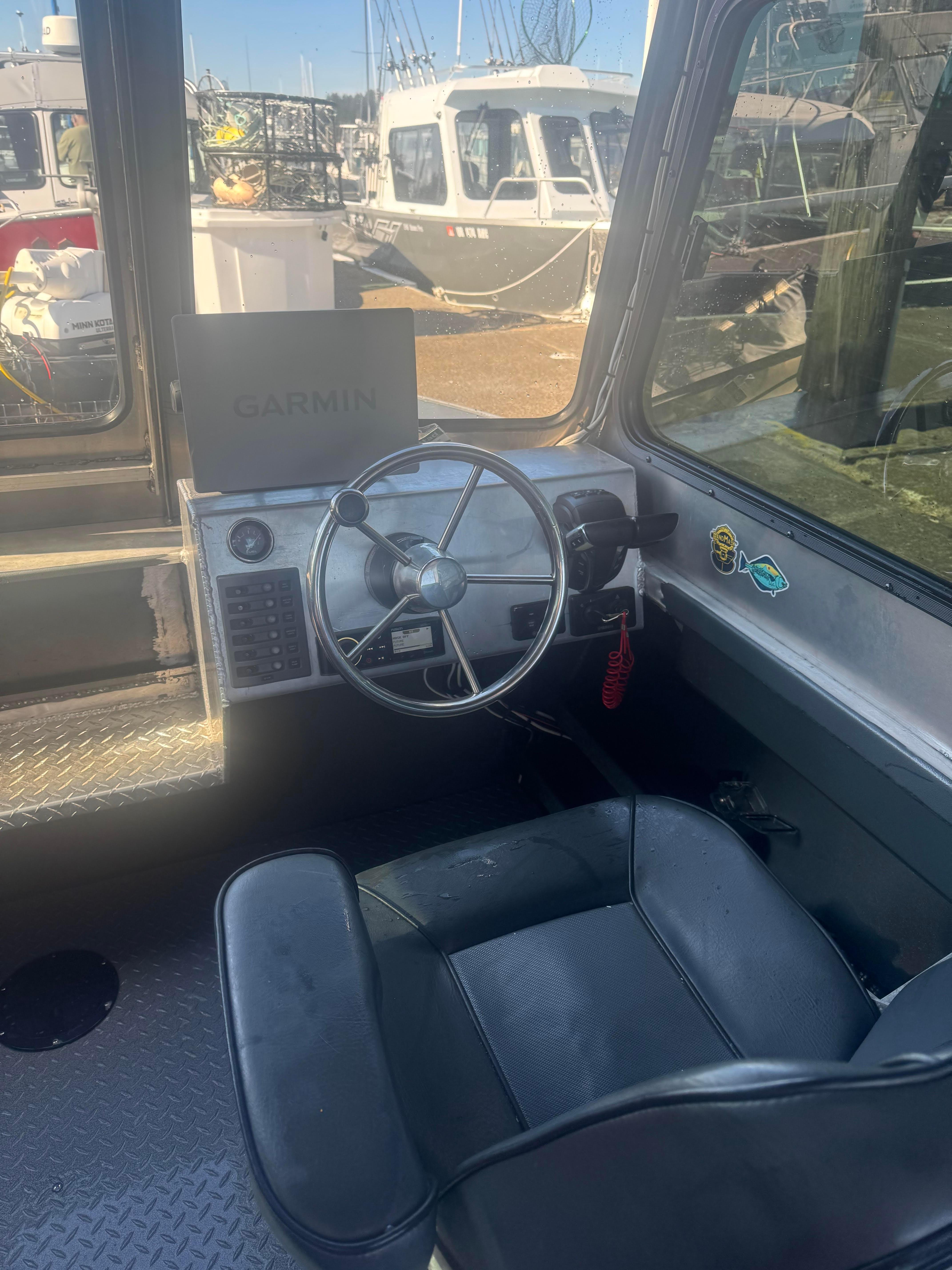 Interior of 2022 Custom Umpqua Marina 26, featuring steering wheel and Garmin navigation system.