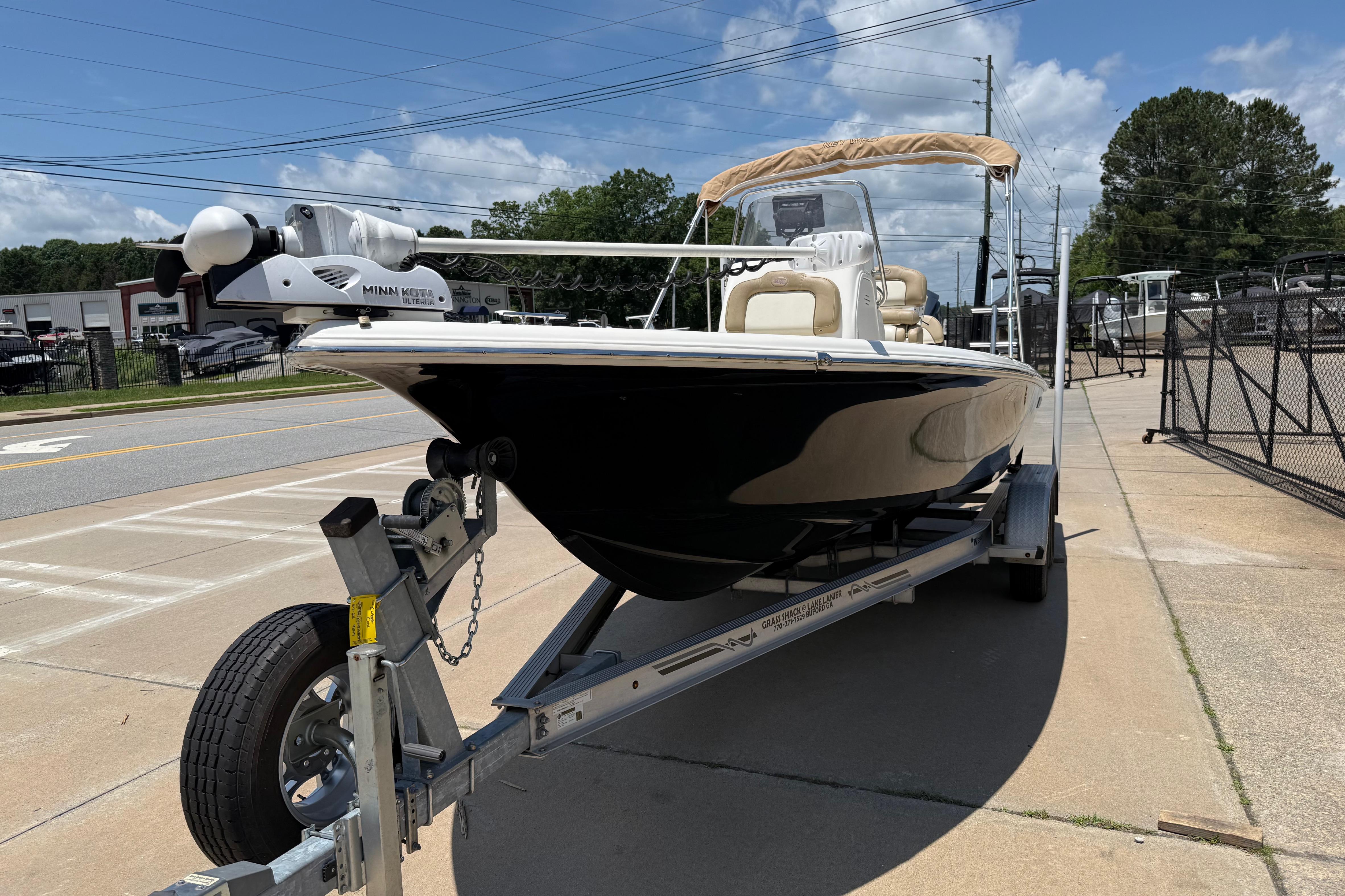 2019 Key West 230 Bay Reef boat on trailer, parked outdoors under clear sky.