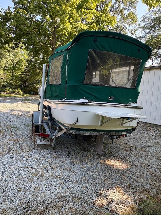A 2007 Ranger Tugs R-21 EC on a trailer with a green canopy.