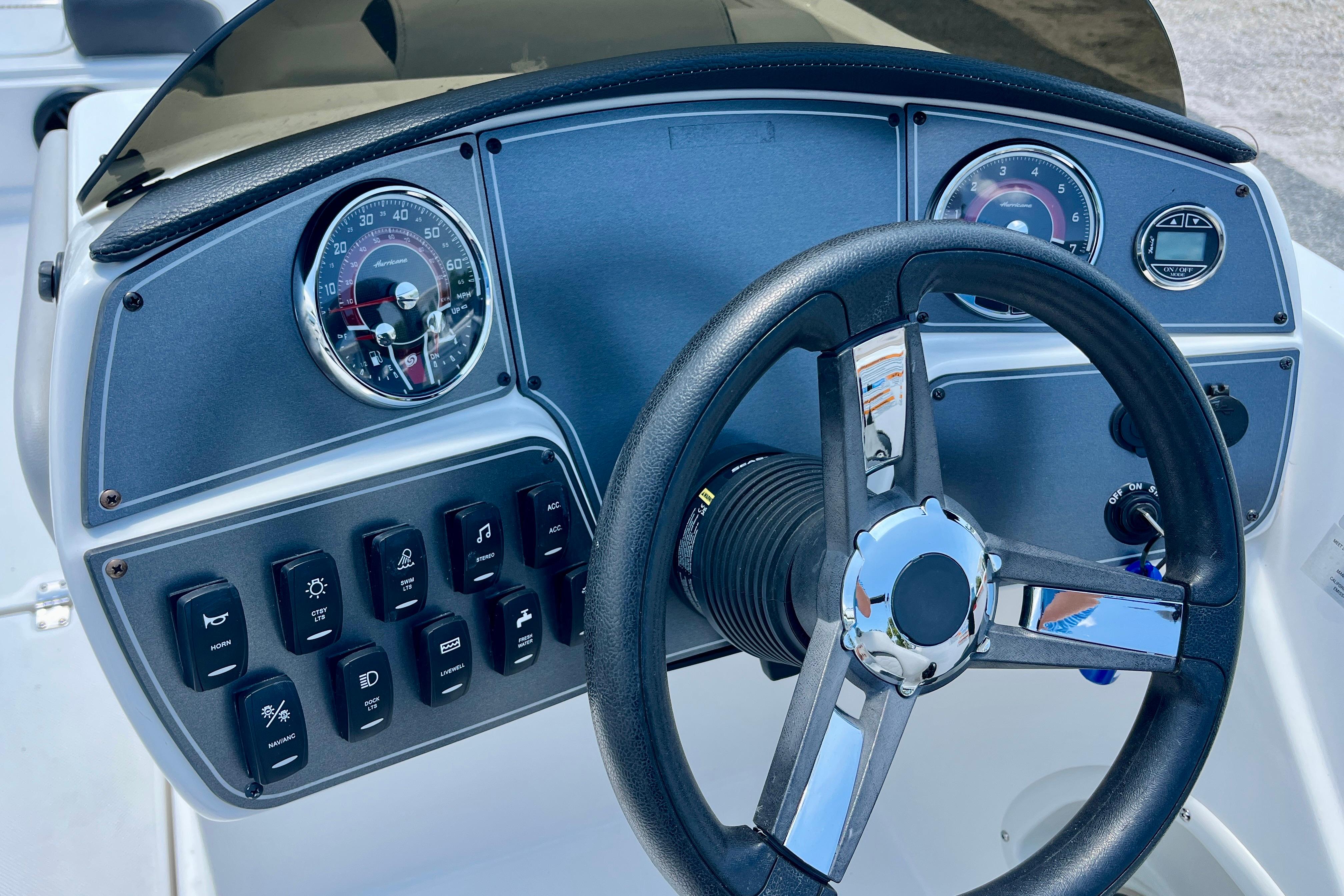 Dashboard of 2024 Hurricane Sundeck Sport 218 OB with steering wheel and controls.