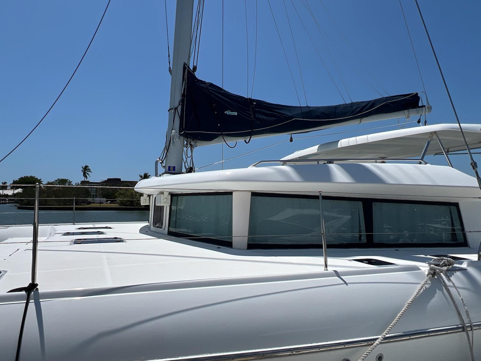 2008 Lagoon 420 catamaran with sails, docked under clear blue sky.