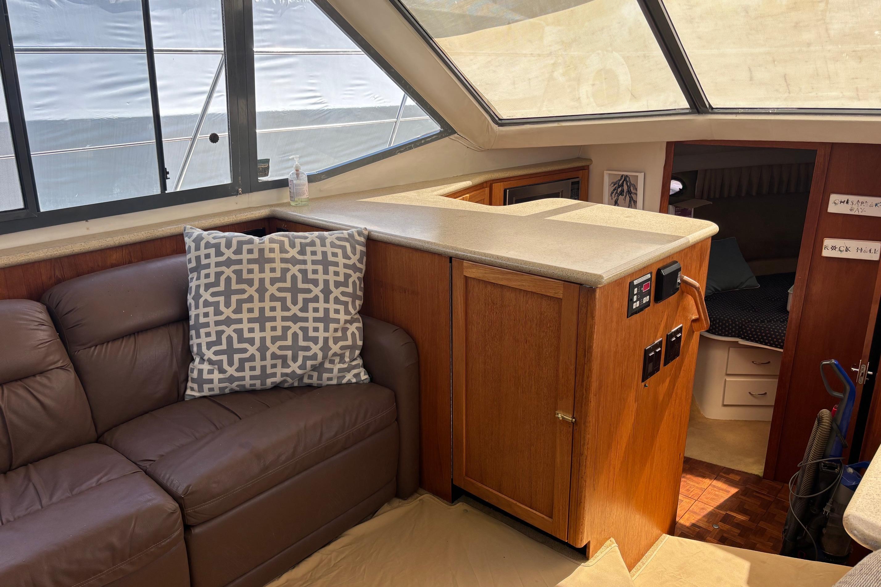 Interior of 1995 Carver 356 Aft Cabin Motor Yacht with leather sofa and wooden cabinetry.