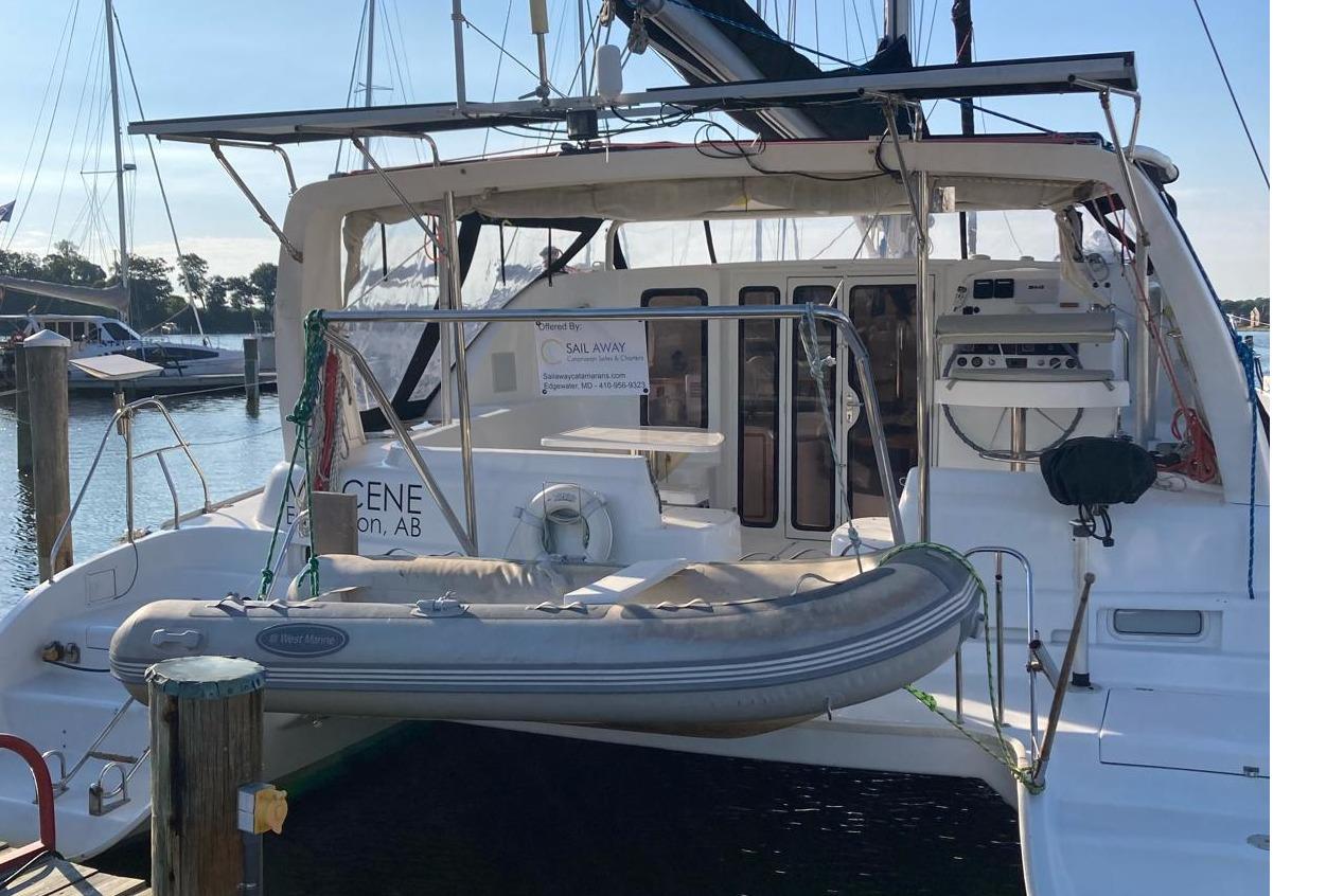 2001 Robertson & Caine Leopard catamaran docked with inflatable dinghy attached.
