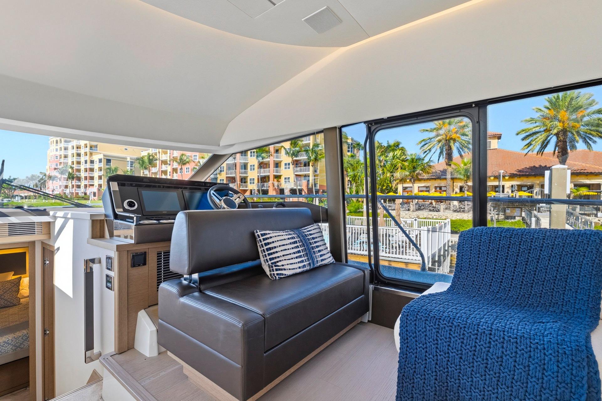 Interior of 2022 Prestige 520 yacht with modern seating and large windows.