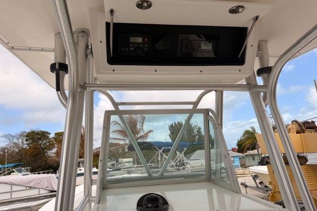2002 Regulator 26 Forward Seating boat console with overhead electronics and clear windshield.