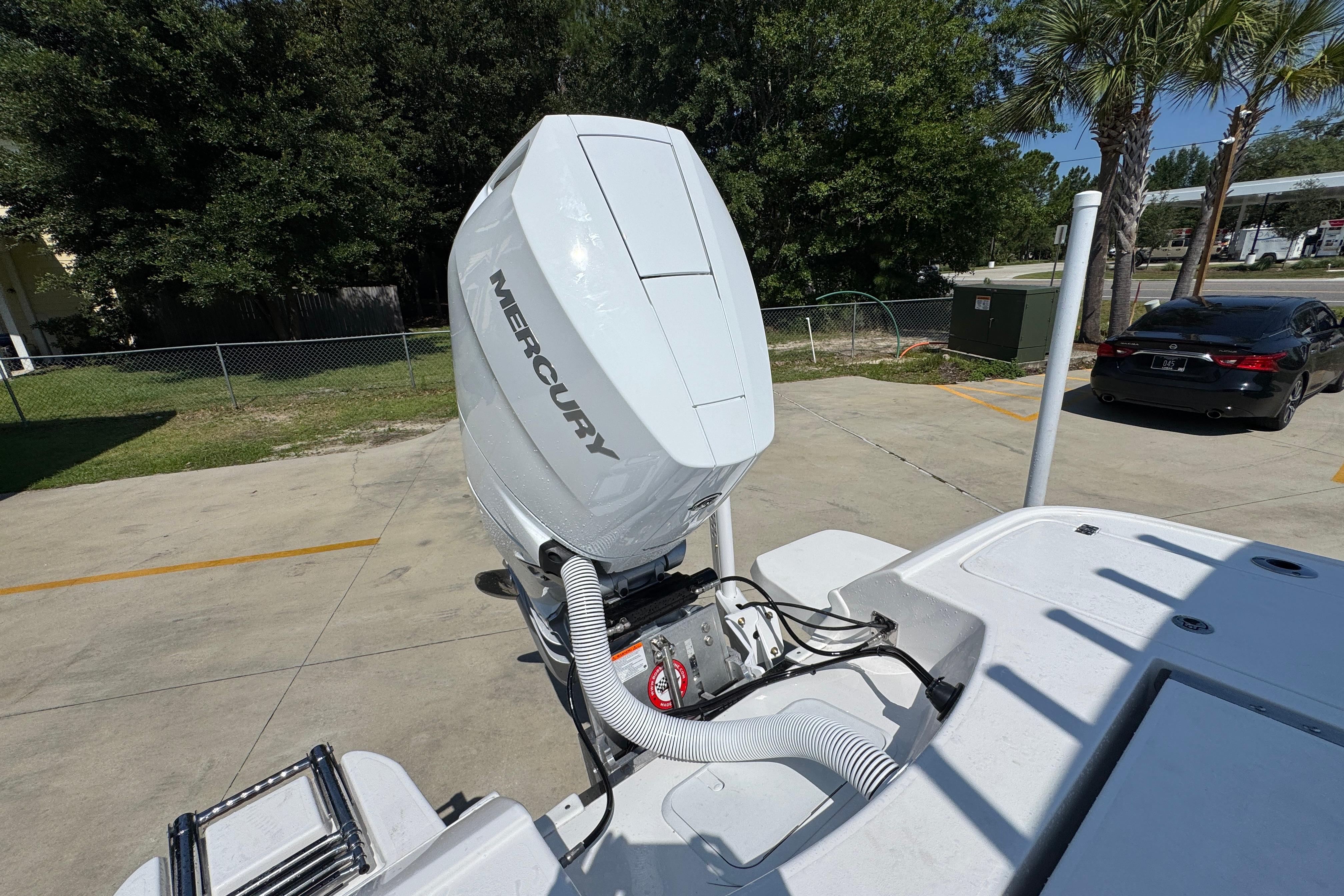 2027 Caymas 26 HB boat with Mercury outboard motor in a sunny parking lot.