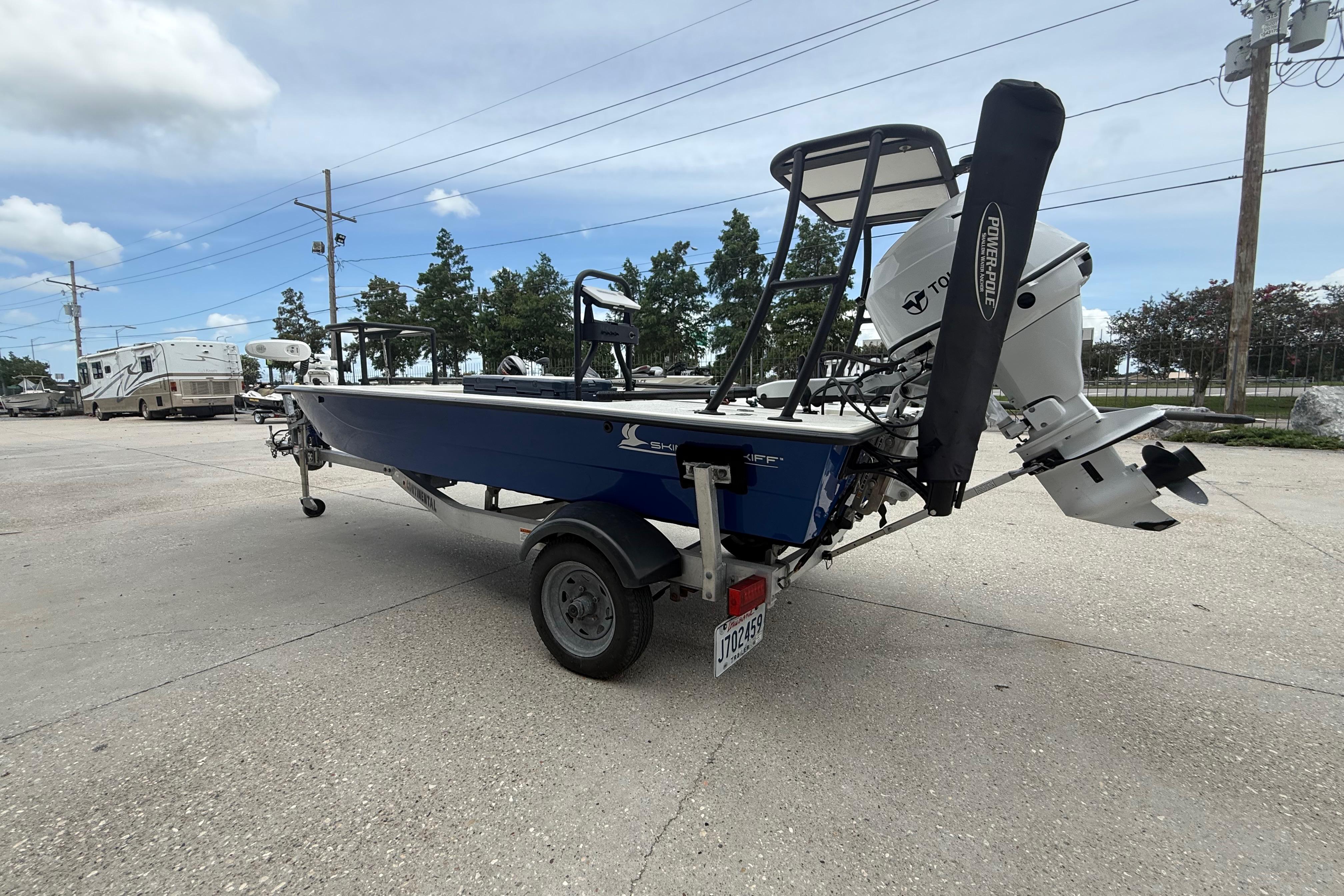 2020 Skimmer Skiff 14 boat with motor on trailer, parked outdoors.