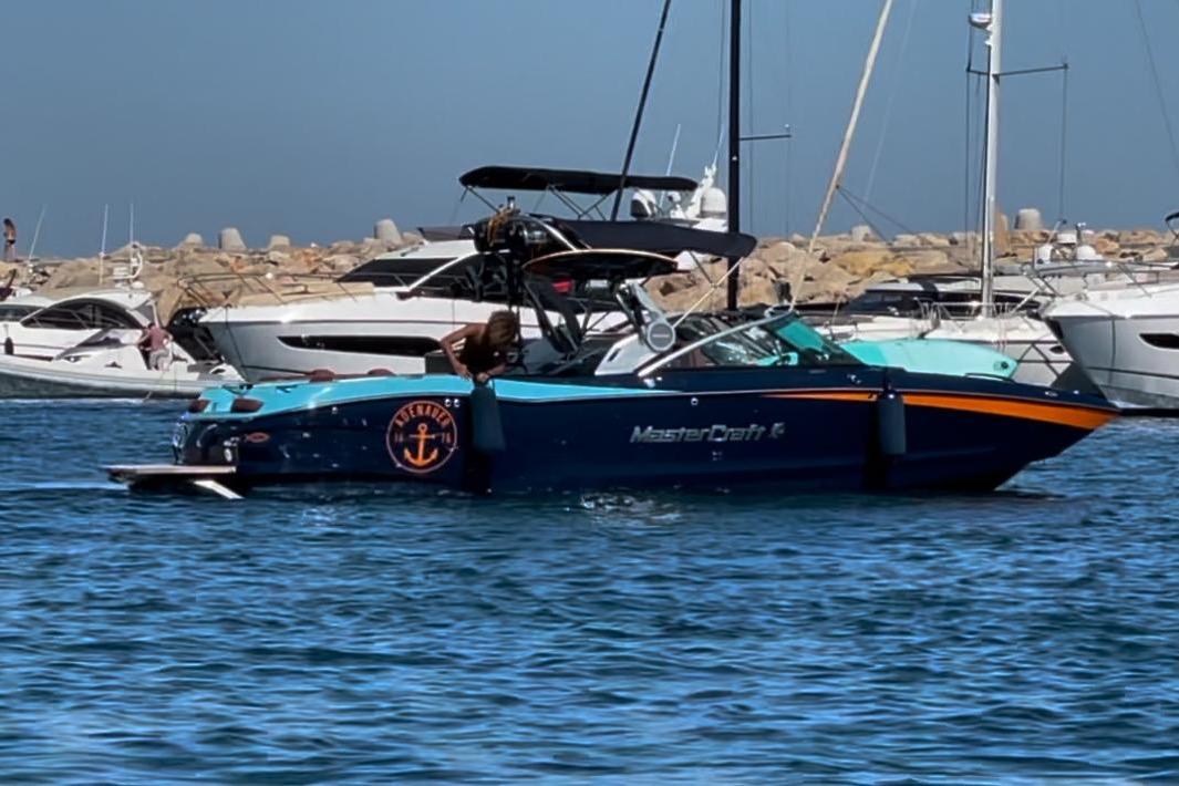 2020 MasterCraft X26 boat in a marina, surrounded by other yachts.