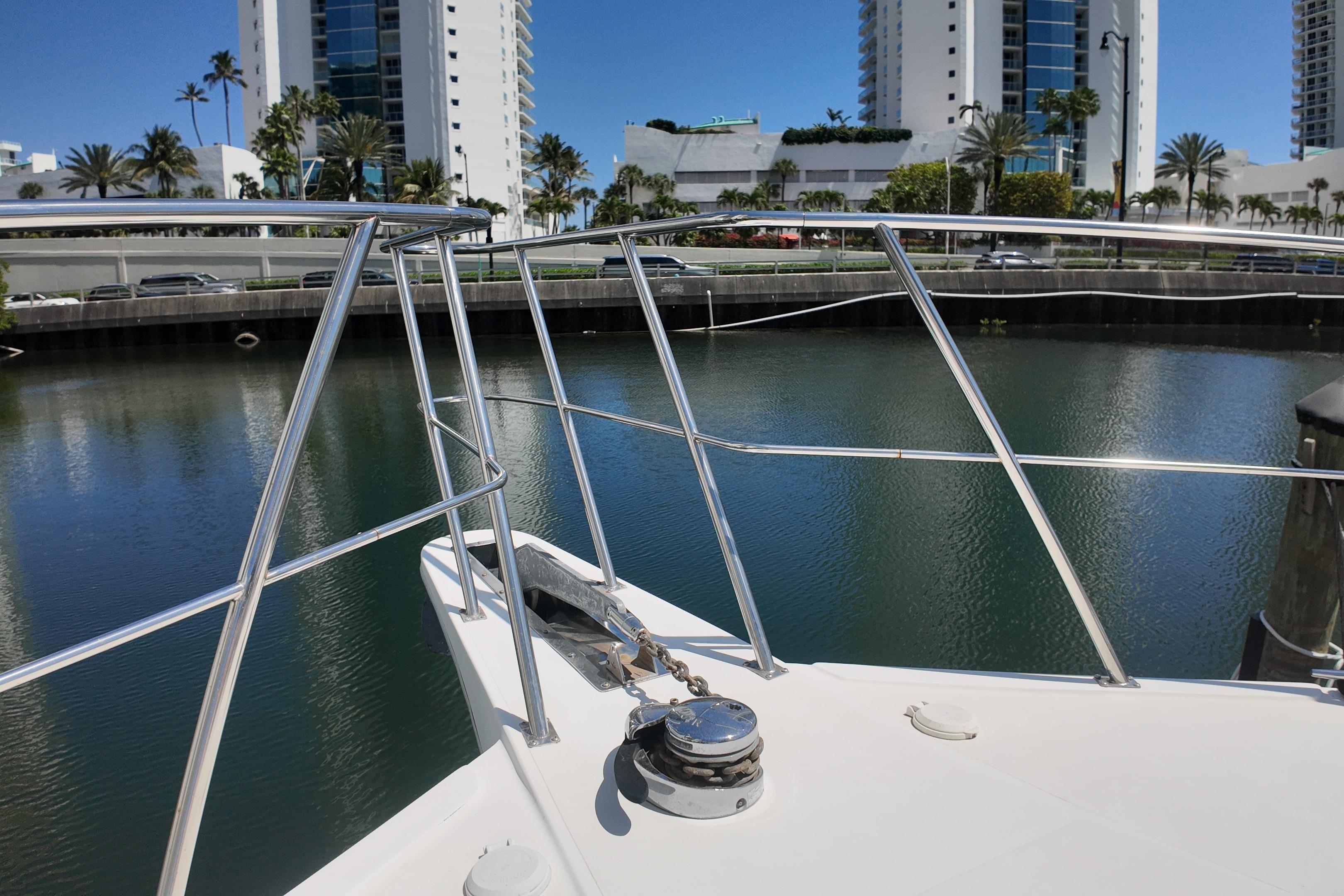 Bow of 2003 Navigator Rival yacht docked near waterfront buildings and palm trees.
