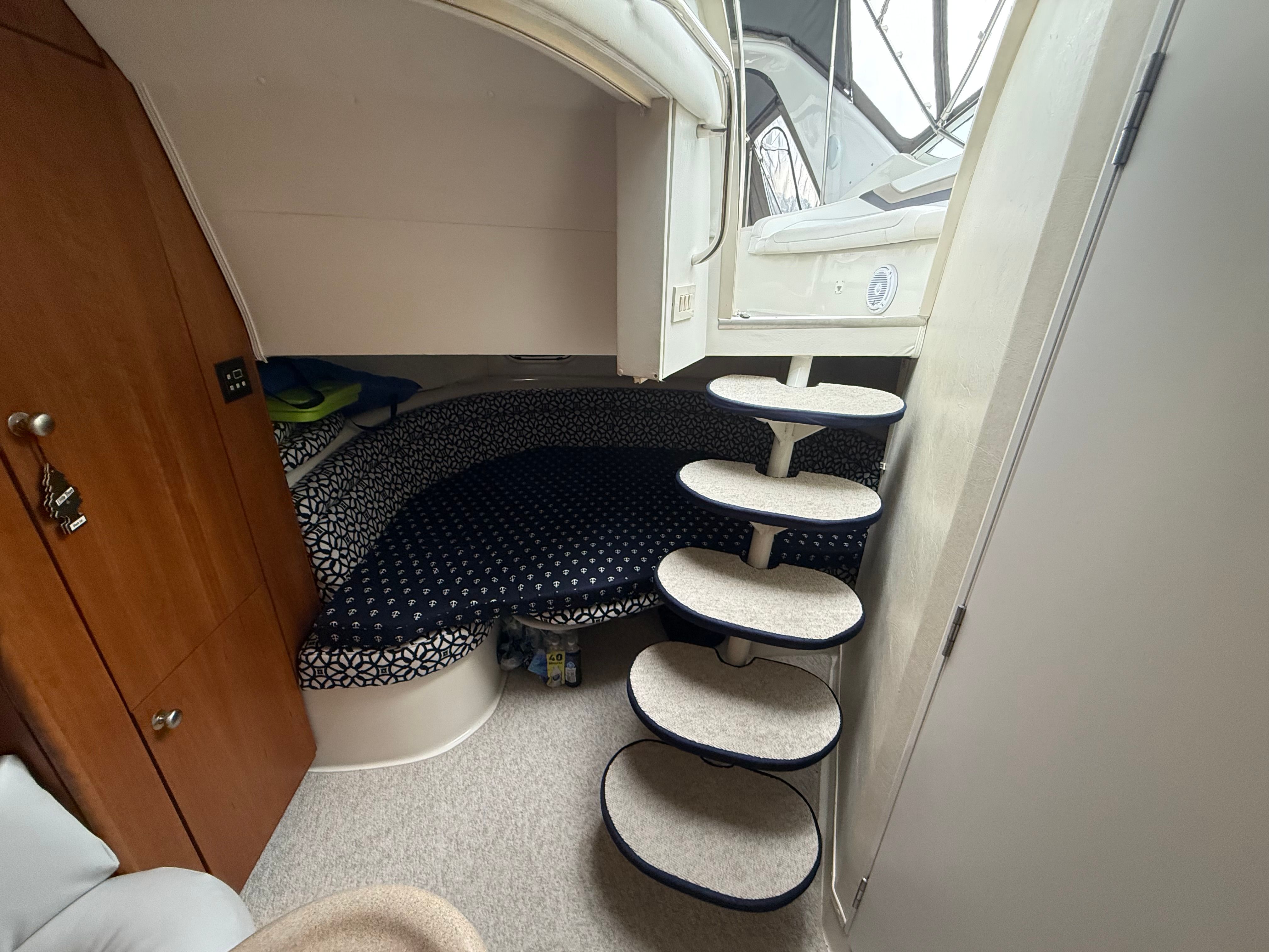 Interior of a 1995 Silverton 360 with a cozy sleeping area and curved staircase.