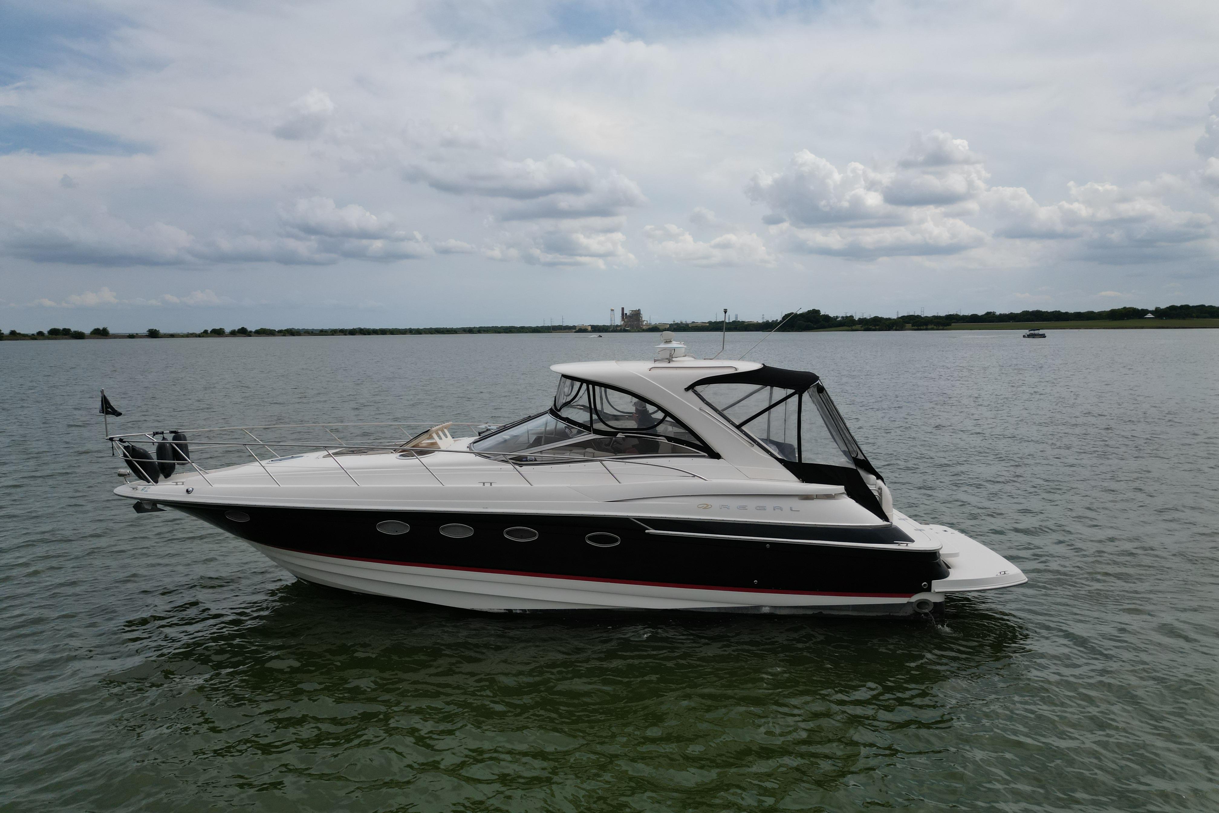 2005 Regal Commodore 4260 yacht on calm water under a cloudy sky.
