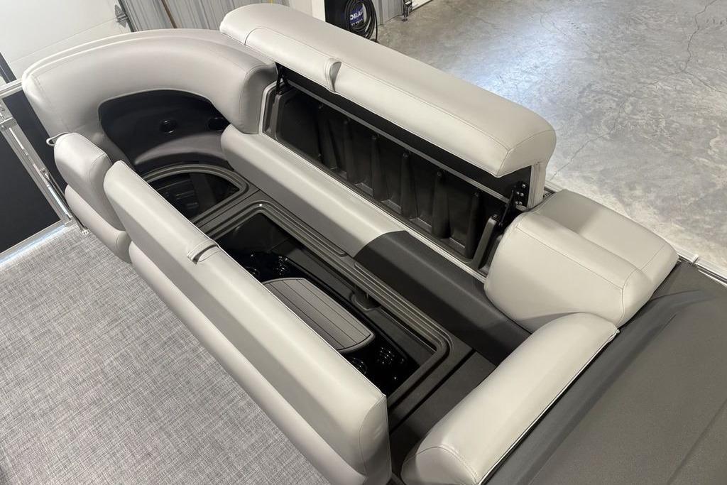 2026 Sun Tracker PARTY BARGE® 20 DLX interior with open storage compartments and gray seating.