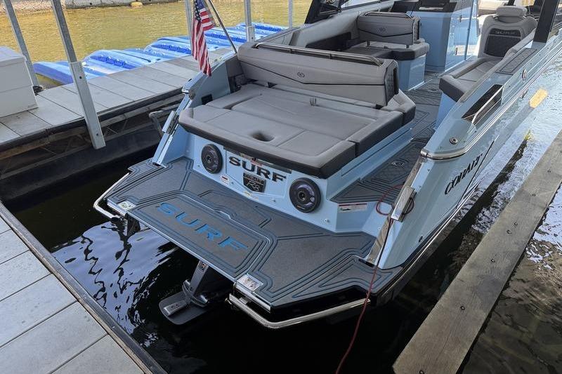 2026 Cobalt R8 Surf boat docked, featuring spacious seating and sleek design.