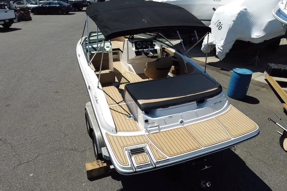2021 Sea Ray SPX 190 boat with black canopy and wooden deck, parked on a trailer.