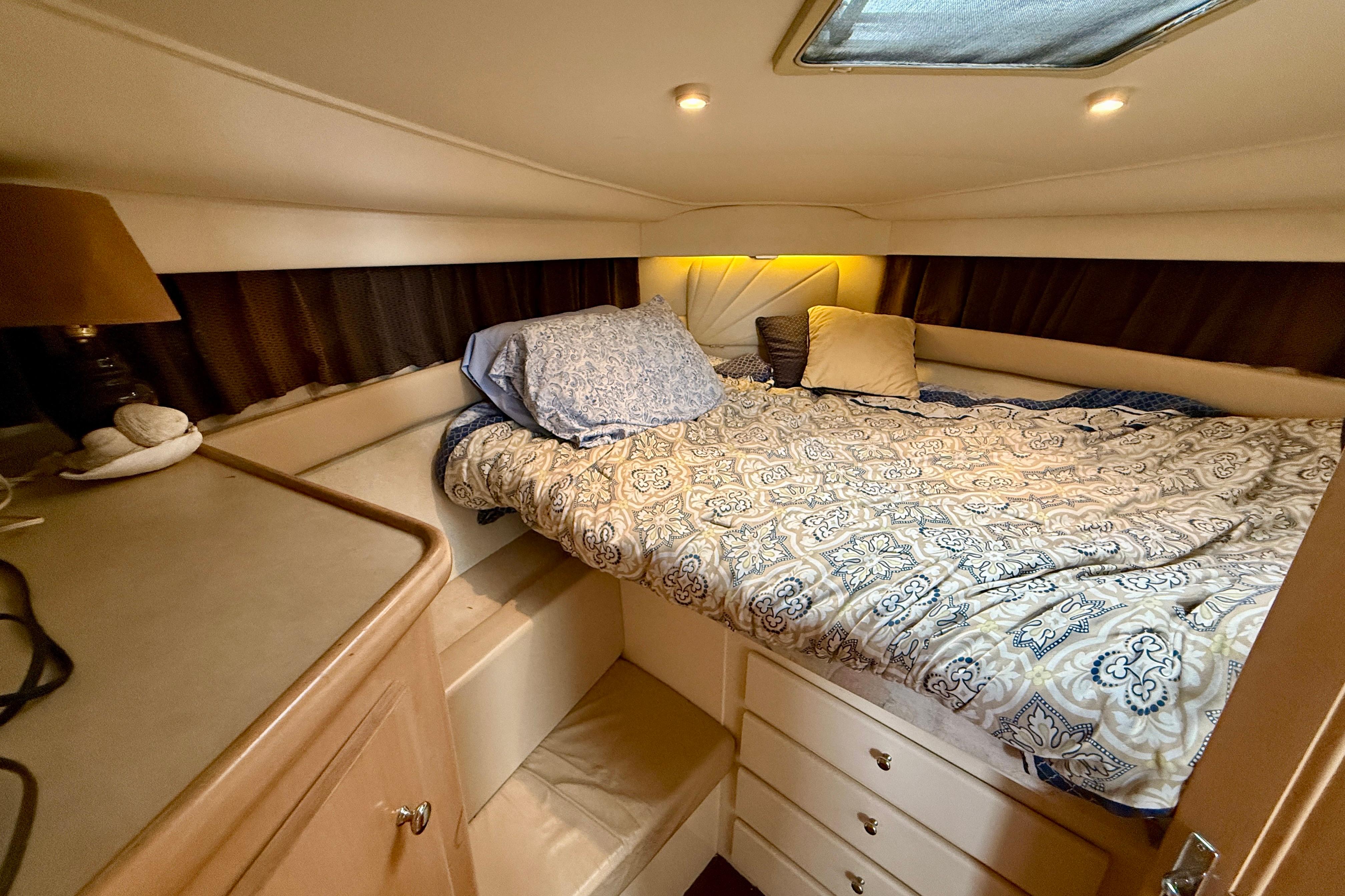 Cozy bedroom in 1997 Carver 355 Aft Cabin Motor Yacht with patterned bedding.