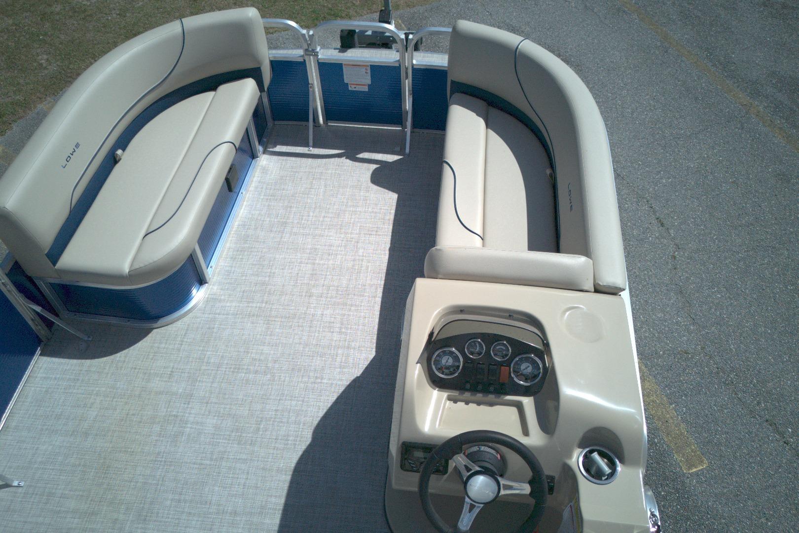 2024 Lowe Ultra 200 Cruise pontoon boat interior with beige seating and steering console.