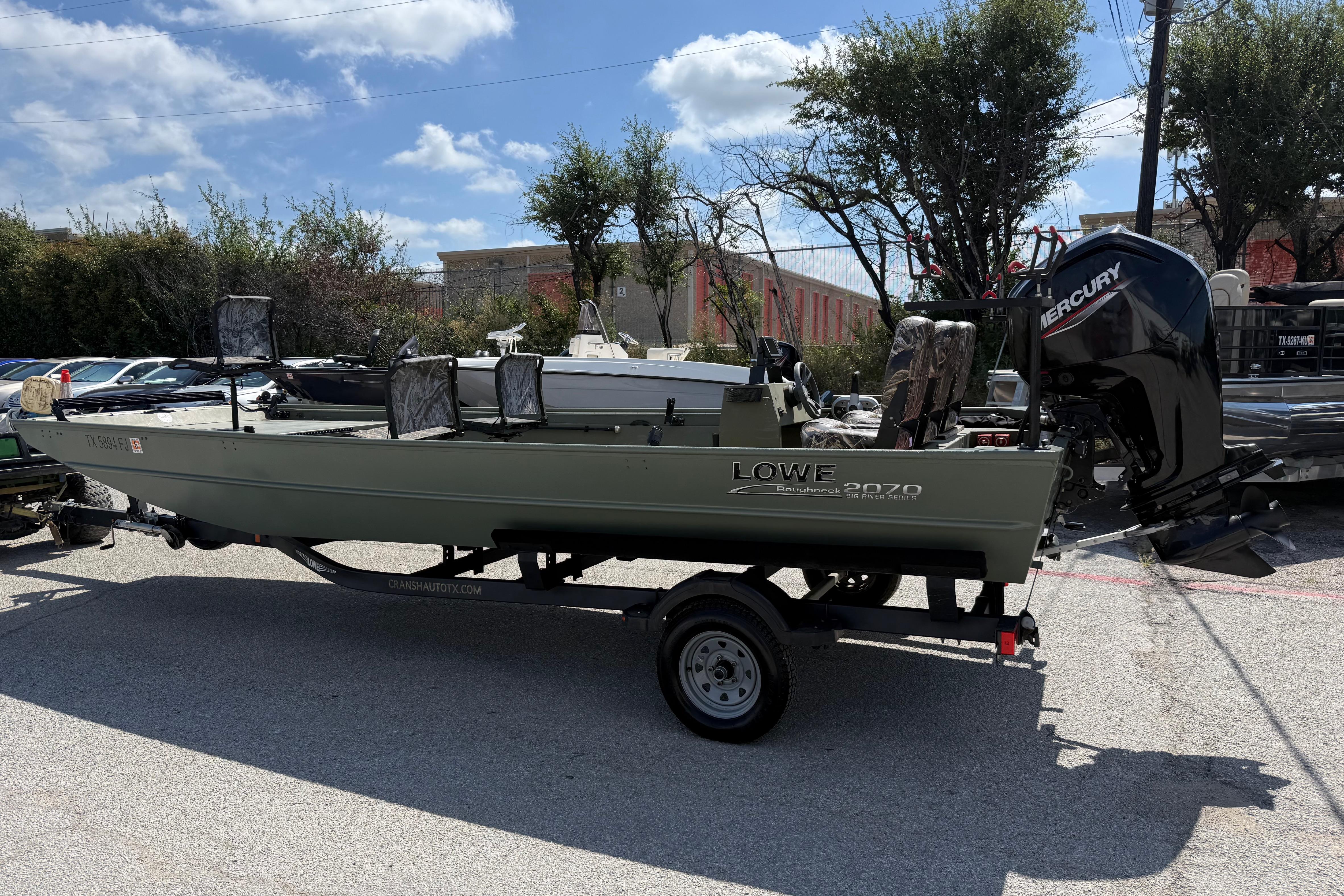 A 2020 Lowe Roughneck 2070 Big River boat on a trailer, parked outdoors.