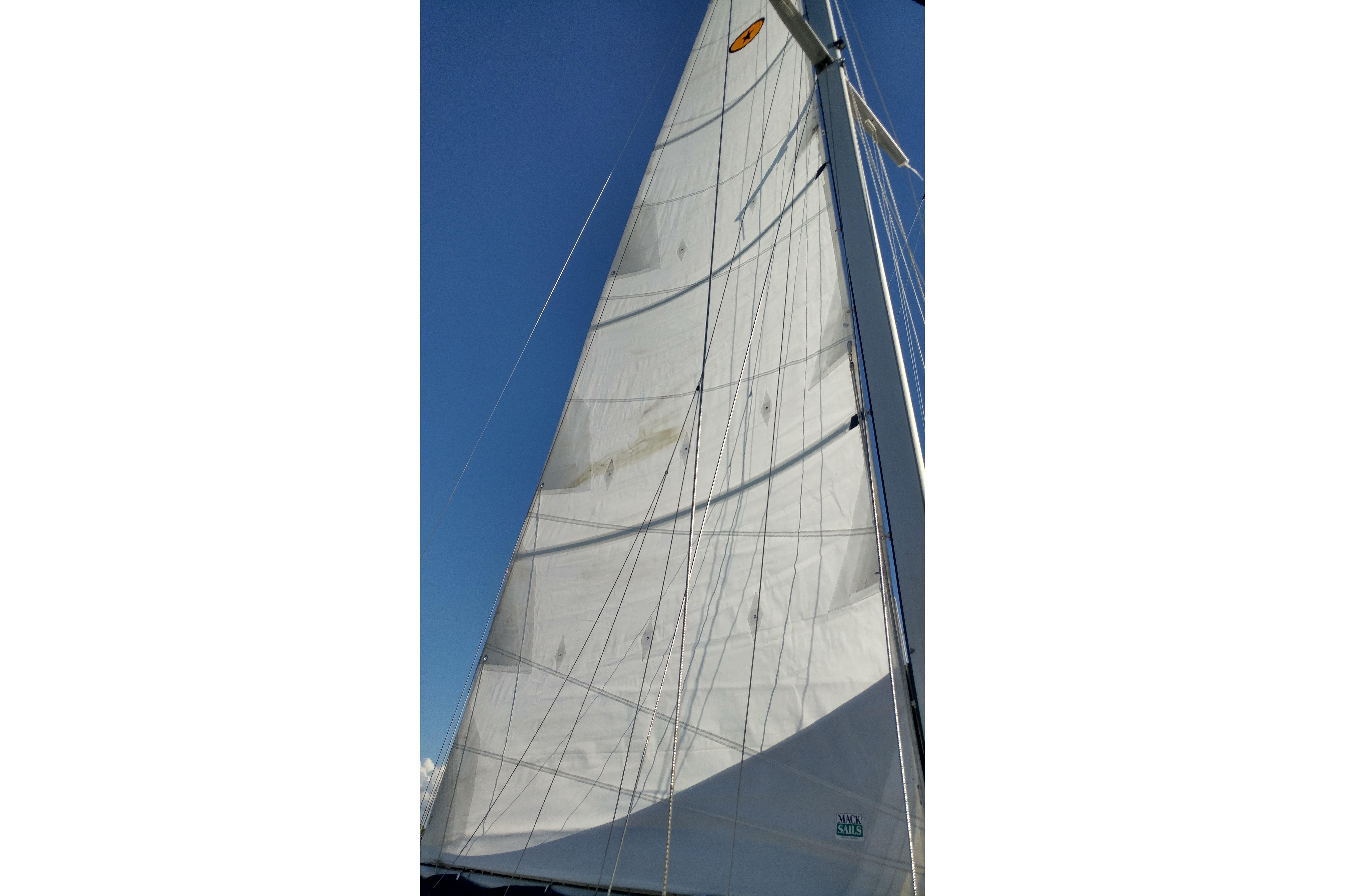 Sail of a 1996 Island Packet 40 yacht against a clear blue sky.