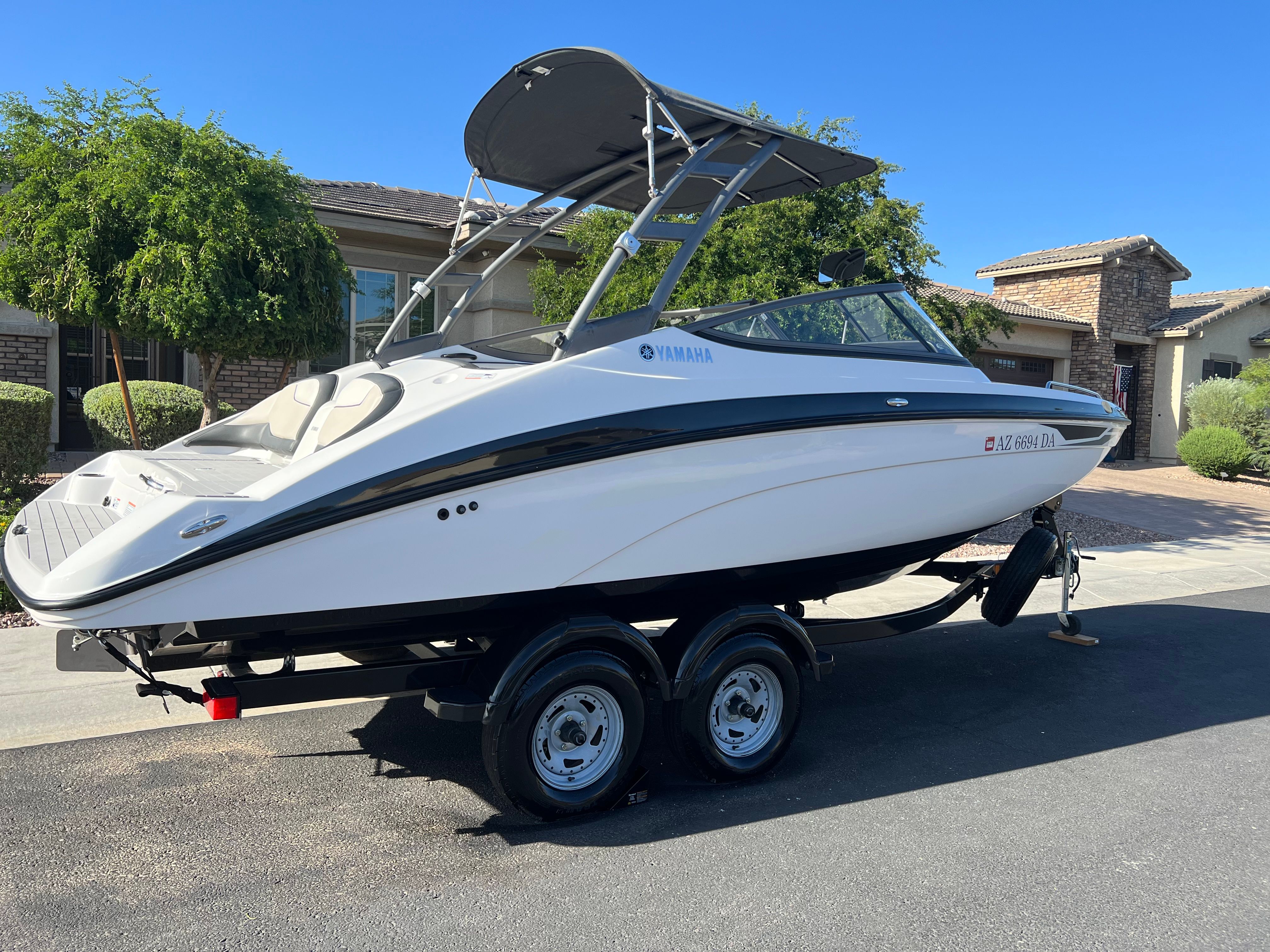 A 2018 Yamaha AR210 boat on a trailer in a residential area.