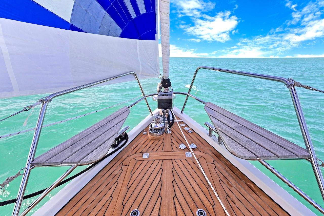 Bow view of 2011 Southerly 57 RS yacht sailing on turquoise sea under clear blue sky.